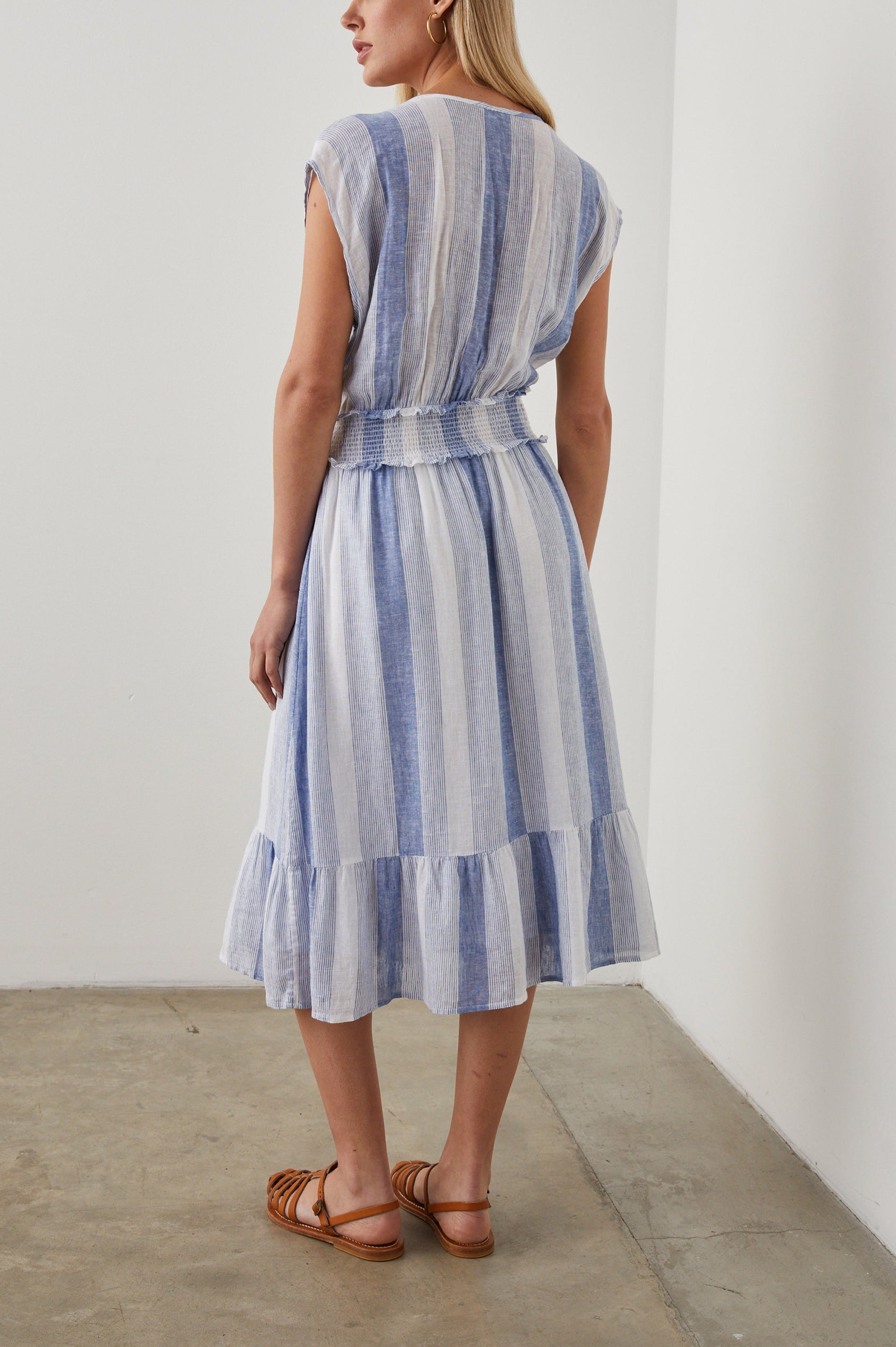 Ashlyn Short Sleeve Midi Dress with a V neck with Ties, a Smocked Waist and a Ruffle Tier at the Hem in Nevis Stripe Colorway, Vertical Stripes in Blue on White - Back Full Body View Featured on Model