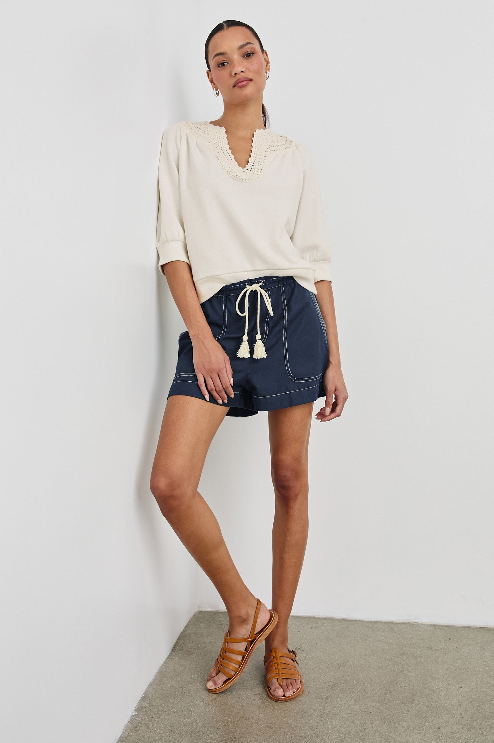 Astra Relaxed Short with an Adjustable Drawcord Waistband and Front Utility Patch Pockets in Navy Colorway with Contrast White Stitching. Full Body Front View Shown on Model.