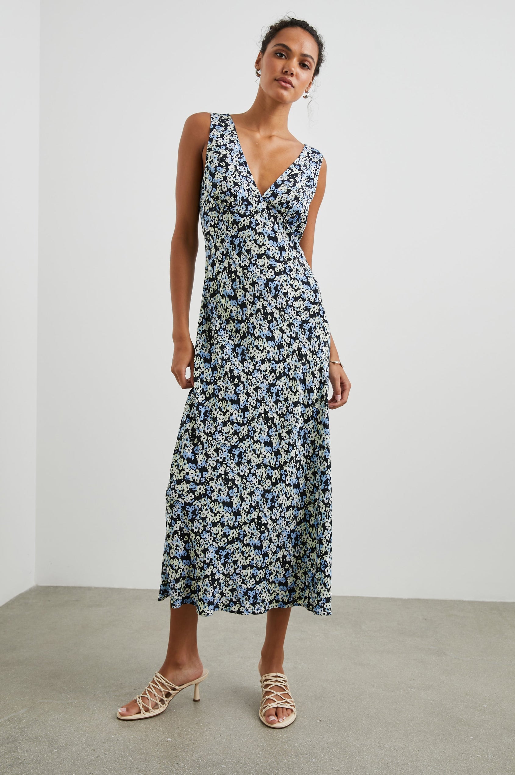 Audrina Sleeveless Midi Dress with Wide Shoulder Straps, a Deep V Neck and V-Back, and an Empire Waist in Midnight Meadow Floral Colorway, cream and blue flowers on Midnight - Front Full Body View Featured on Model 