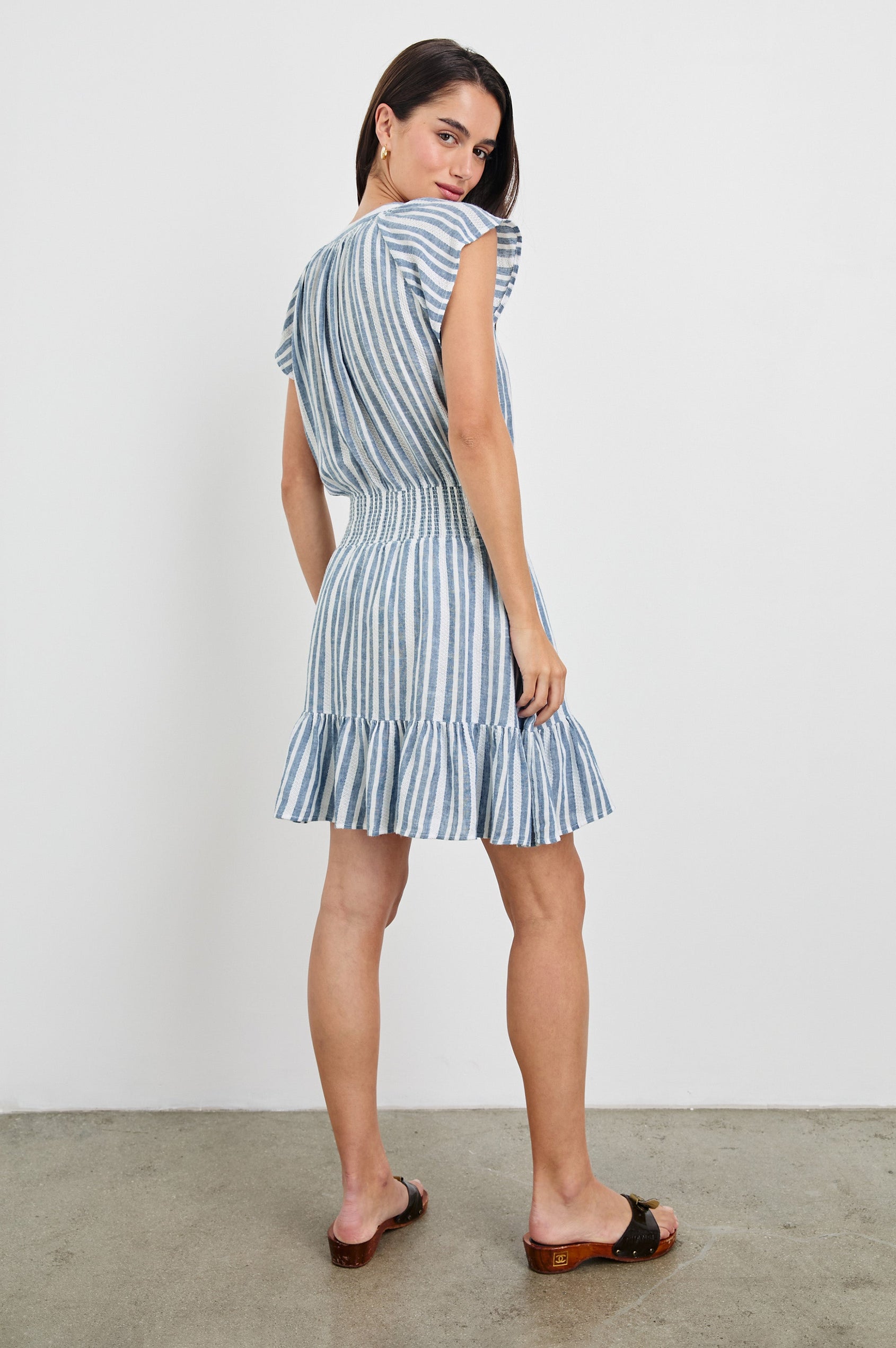 Augustine Mini Dress with Flutter Sleeves, V-Neck Button Front, Elastic Gathered Waist and a Tiered Flounce Hem in Jalisco Stripe Colorway. Full Body Back View Shown on Model.