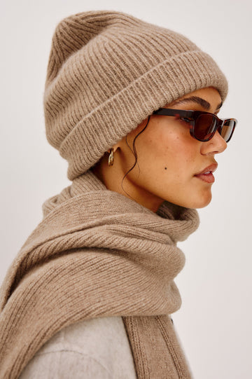 Autumn cashmere beanie in Oat colorway. side view featured on model.