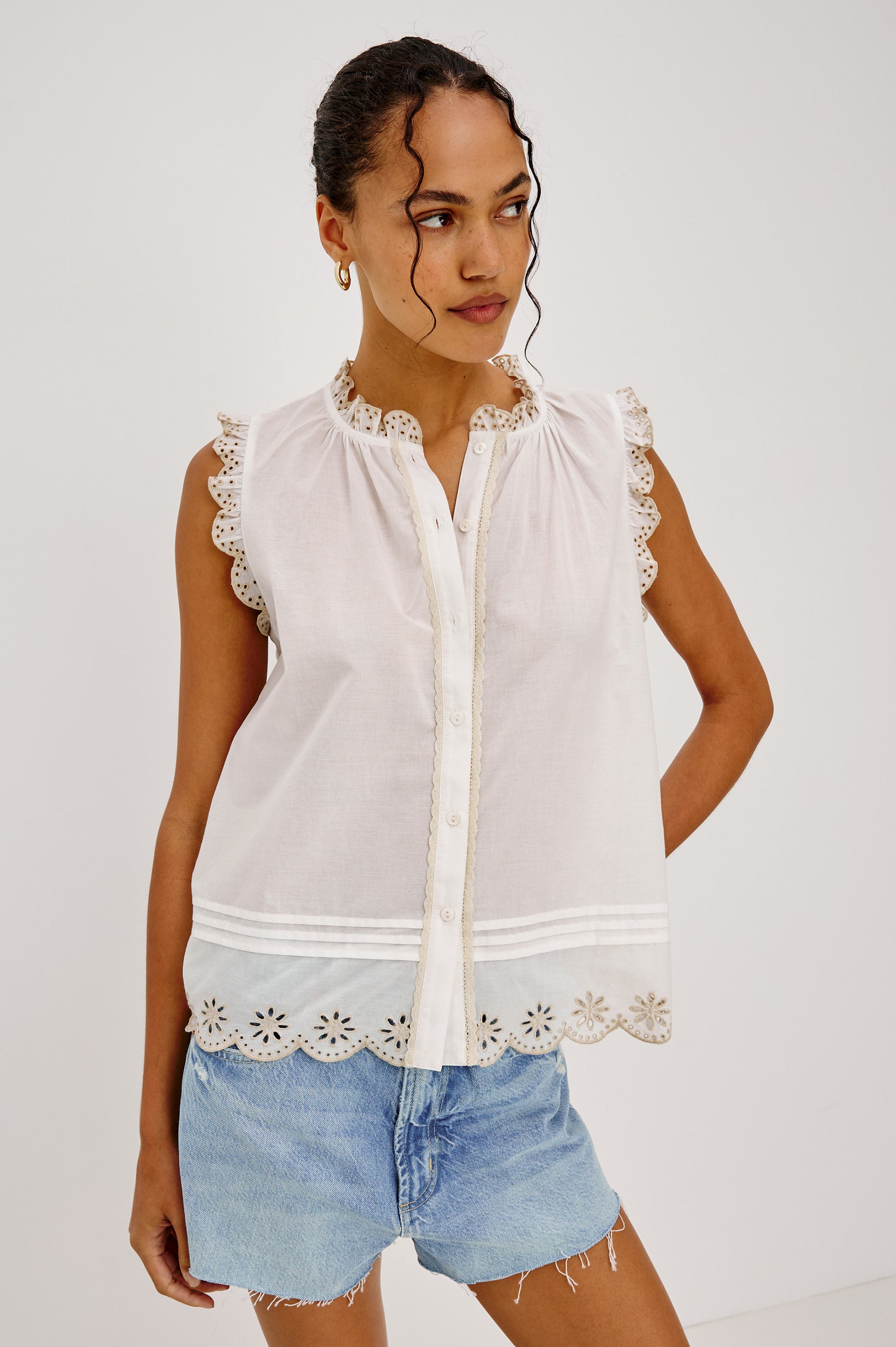 Avery Sleeveless Top in Cotton Voile With Scalloped Embroidered Trim, Front Buttons, and Relaxed Fit in White Colorway - Upper Body View Featured on Model Sitting