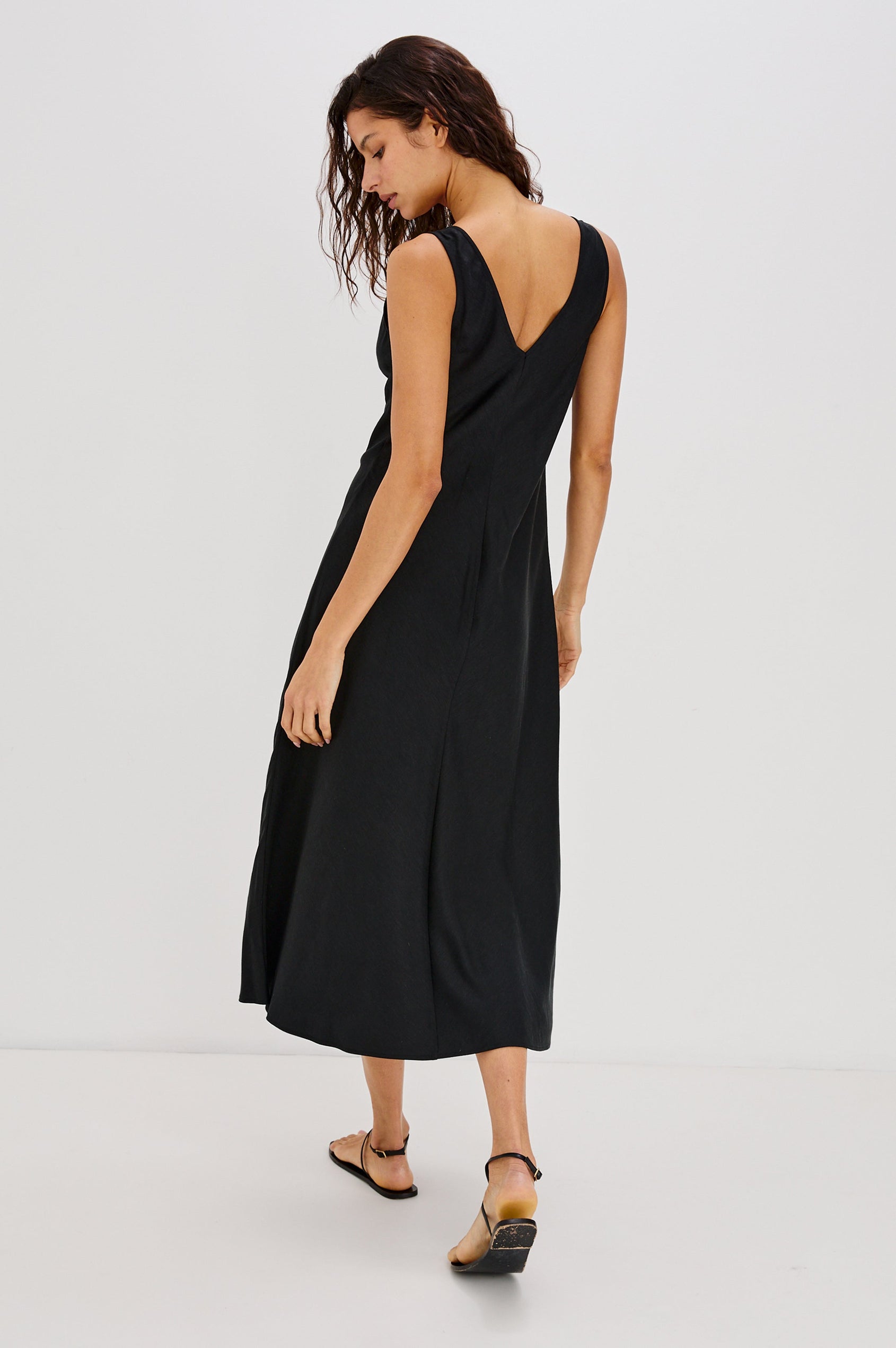 Avila V-Neck, A-Line Tank Dress, Midi Length with Spiral Metal Hardware at Center Front Bust in Black Colorway. Full Body Back View Shown on Model.