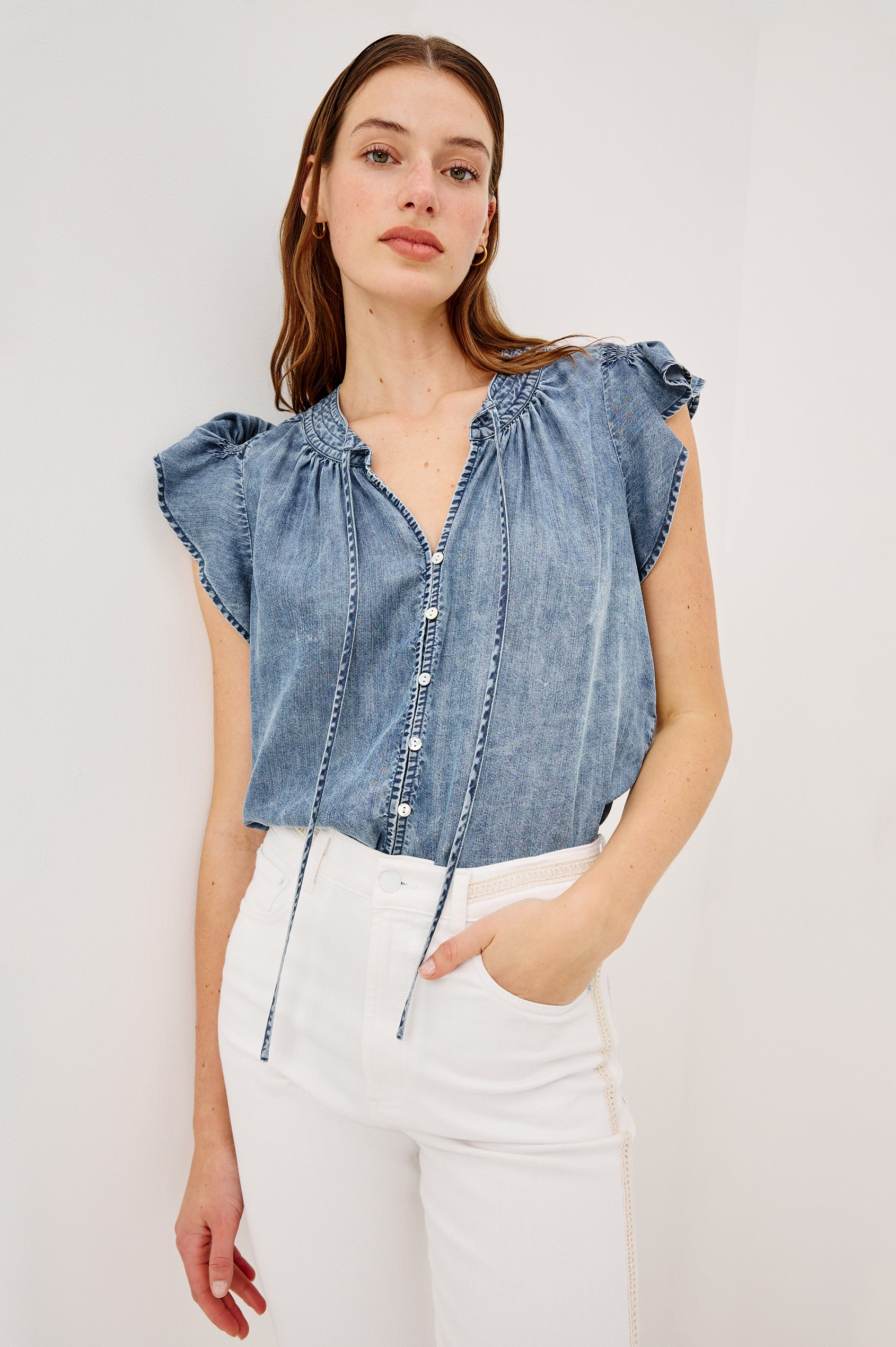 Aviva Top in TENCEL™ Denim With Smocked Flutter Sleeves Split V-Neck With Embroidered Collar and Self-Ties and Front Buttons in Blue Ridge Colorway - Upper Body Close Up View Featured on Model
