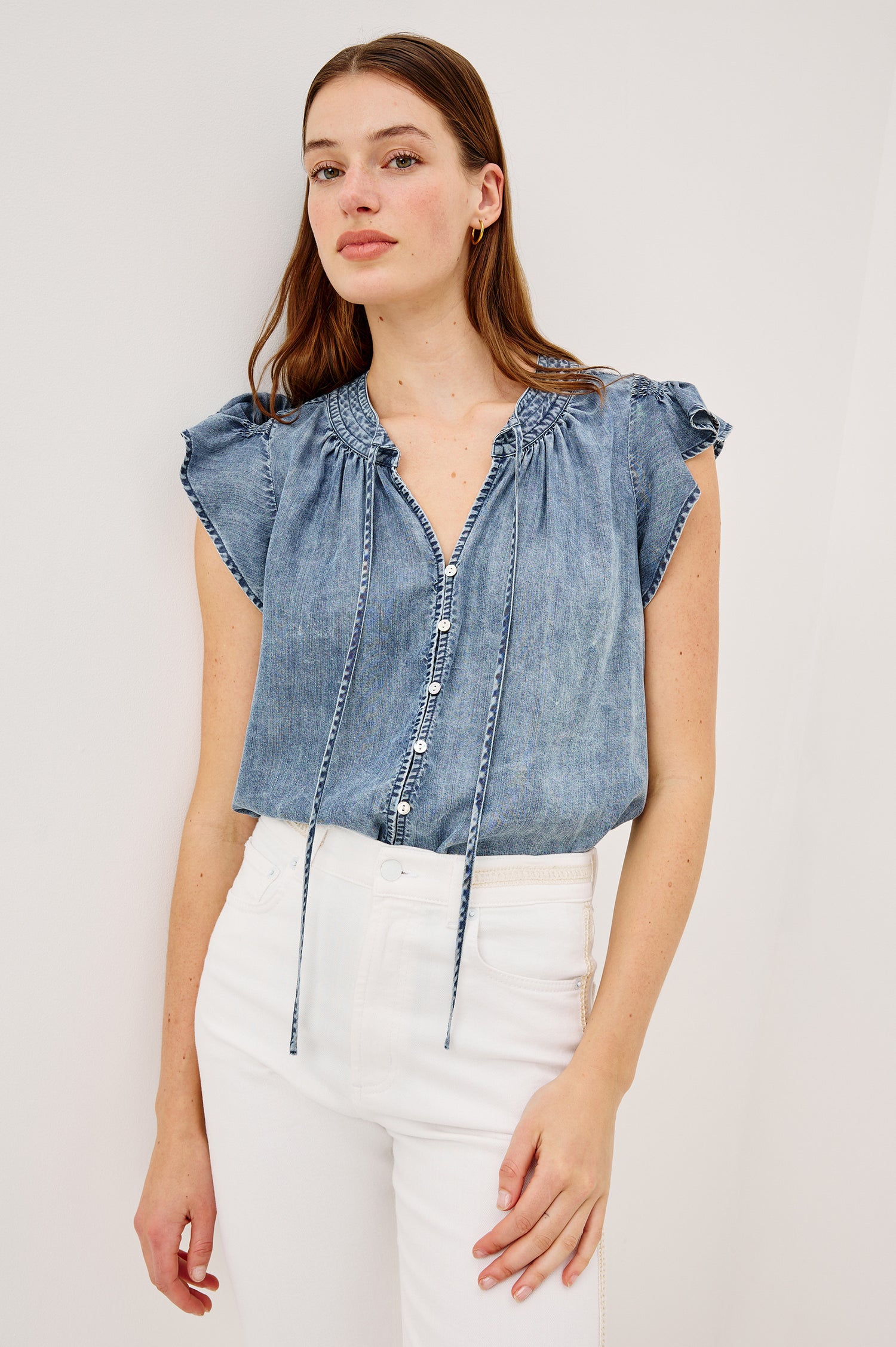 Aviva Top in TENCELâ„¢ Denim With Smocked Flutter Sleeves Split V-Neck With Embroidered Collar and Self-Ties and Front Buttons in Blue Ridge Colorway - Upper Body Front View Featured on Model