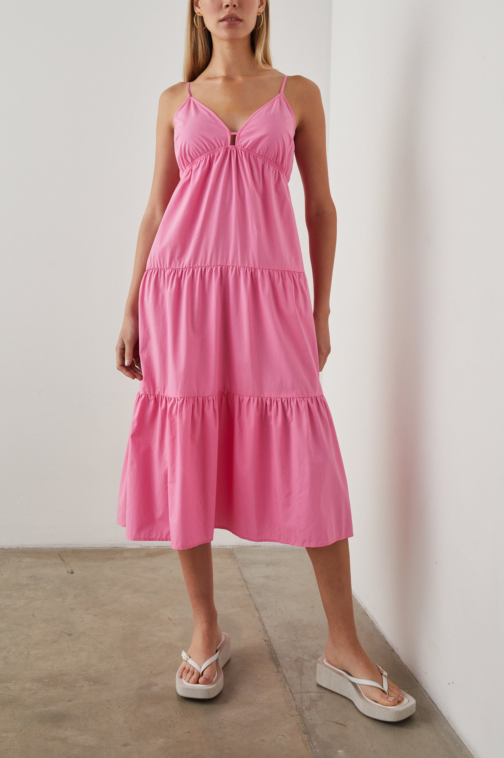 Avril Sleeveless, Tiered Midi Dress with Adjustable Spaghetti Straps, a V Neck with a Cutout and Light Ruching at Each Tier Seam in Hot Pink Colorway - Front Full Body View Featured on Model 