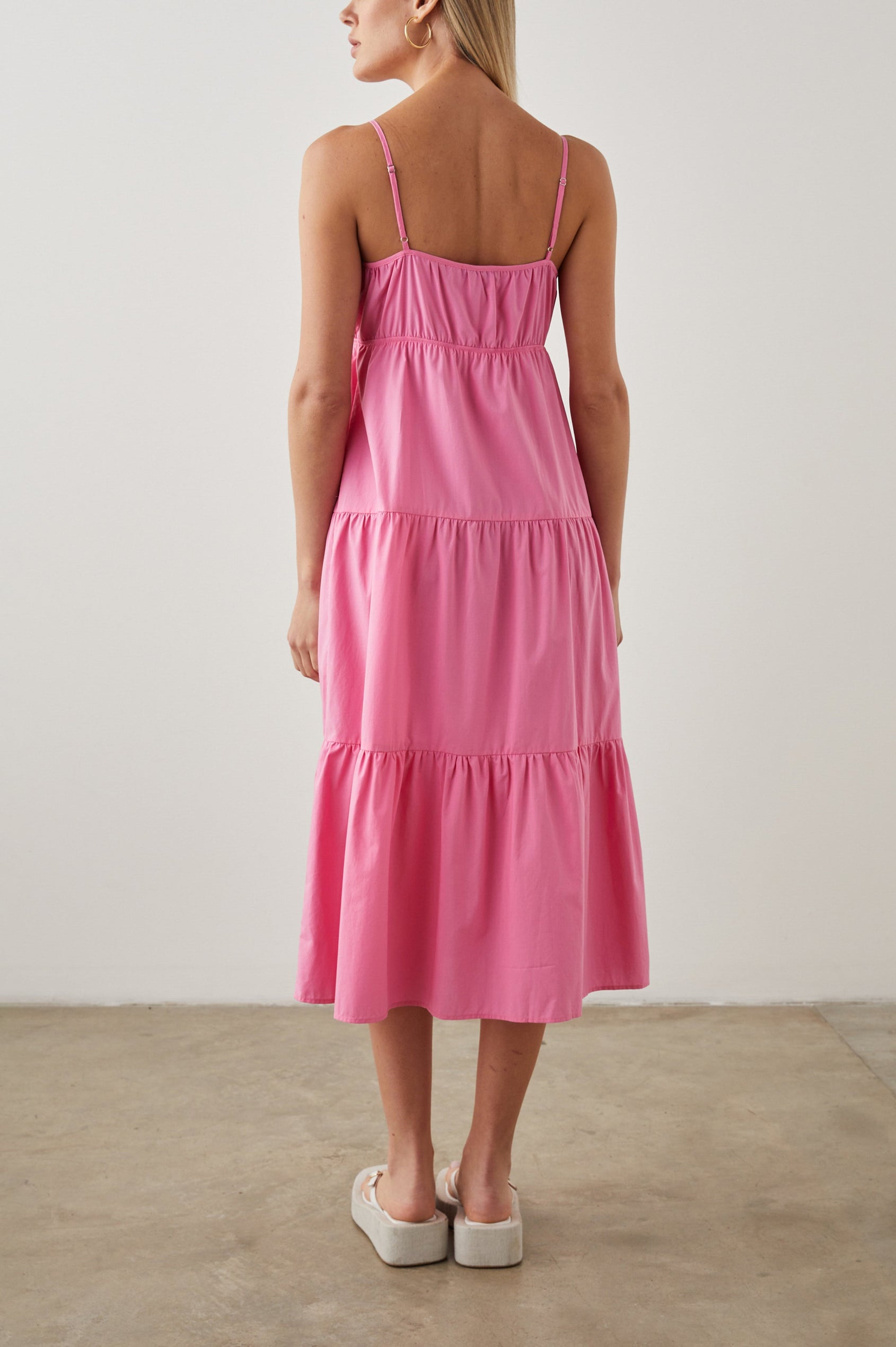 Avril Sleeveless, Tiered Midi Dress with Adjustable Spaghetti Straps, a V Neck with a Cutout and Light Ruching at Each Tier Seam in Hot Pink Colorway - Back Full Body View Featured on Model 