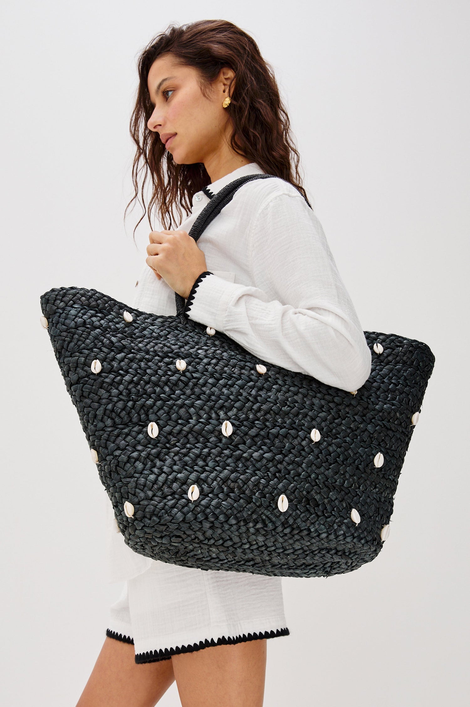 Baltic Seas Large Straw Tote Bag with Sea Shell Trim in Black Colorway. Side View Shown on Model.