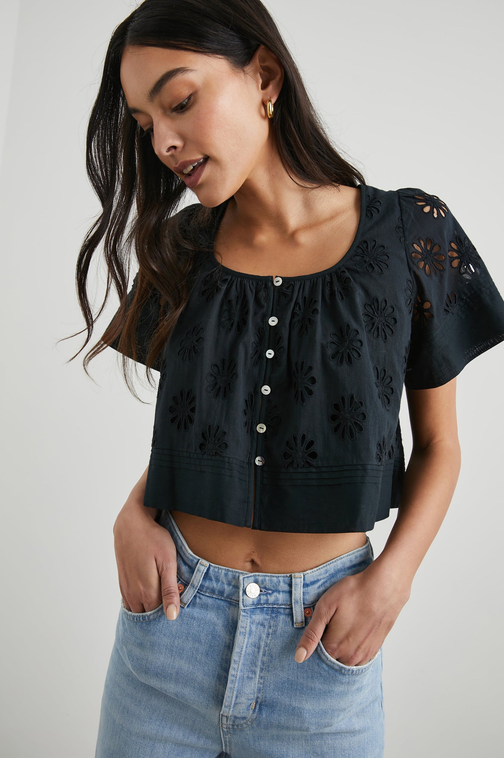 Bambina Short-Sleeve Cropped Top with a Scoop Neck, Buttons Down the Front, and Floral Eyelets in Black Colorway - Front View Featured on Model 