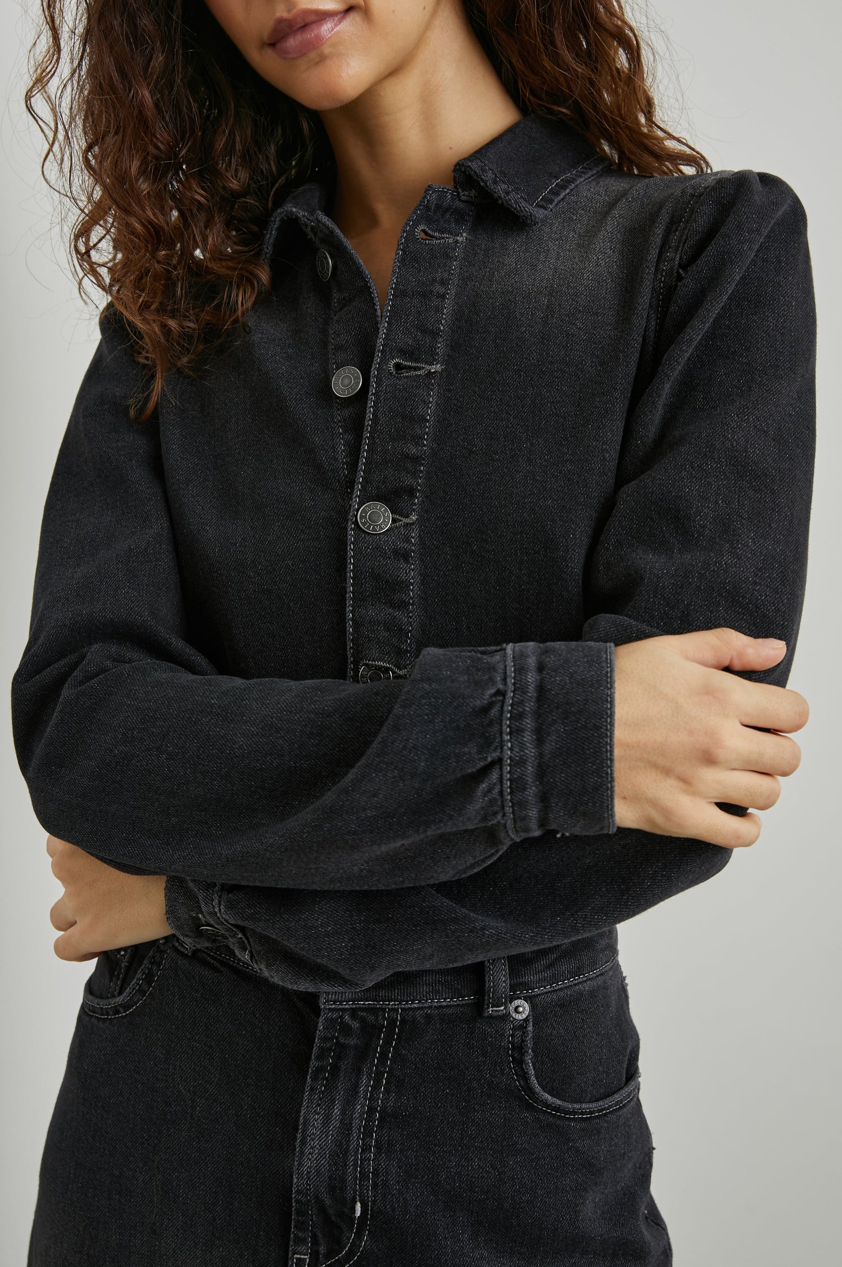 Beverly Long Sleeve Denim Knee Dress with a Back Vent, Belt Loops, a Button and Zipper Closure for the Skirt and Button Closure on the Bodice, a Collar, two Front Pockets plus a Coin Pocket and Two Back Patch Pockets in Eclipse Colorway, a Black - Front View Featured on Model