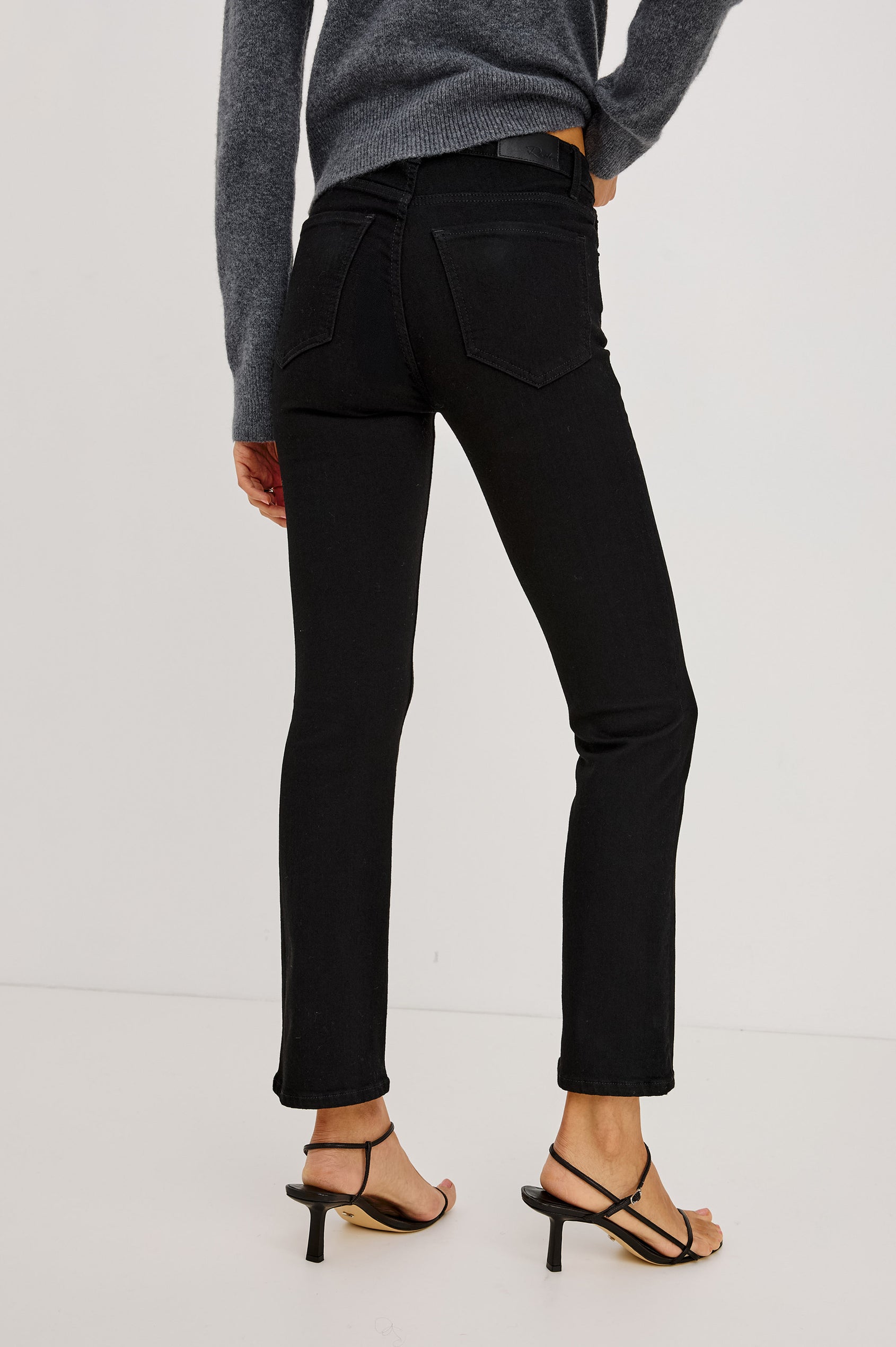 Bixby Slim Jean in High-Stretch Denim With Mid-Rise, Slim Legs, Zip Fly, and Ankle-Length Inseam in Blackout Colorway - Lower Body Back View Featured on Model