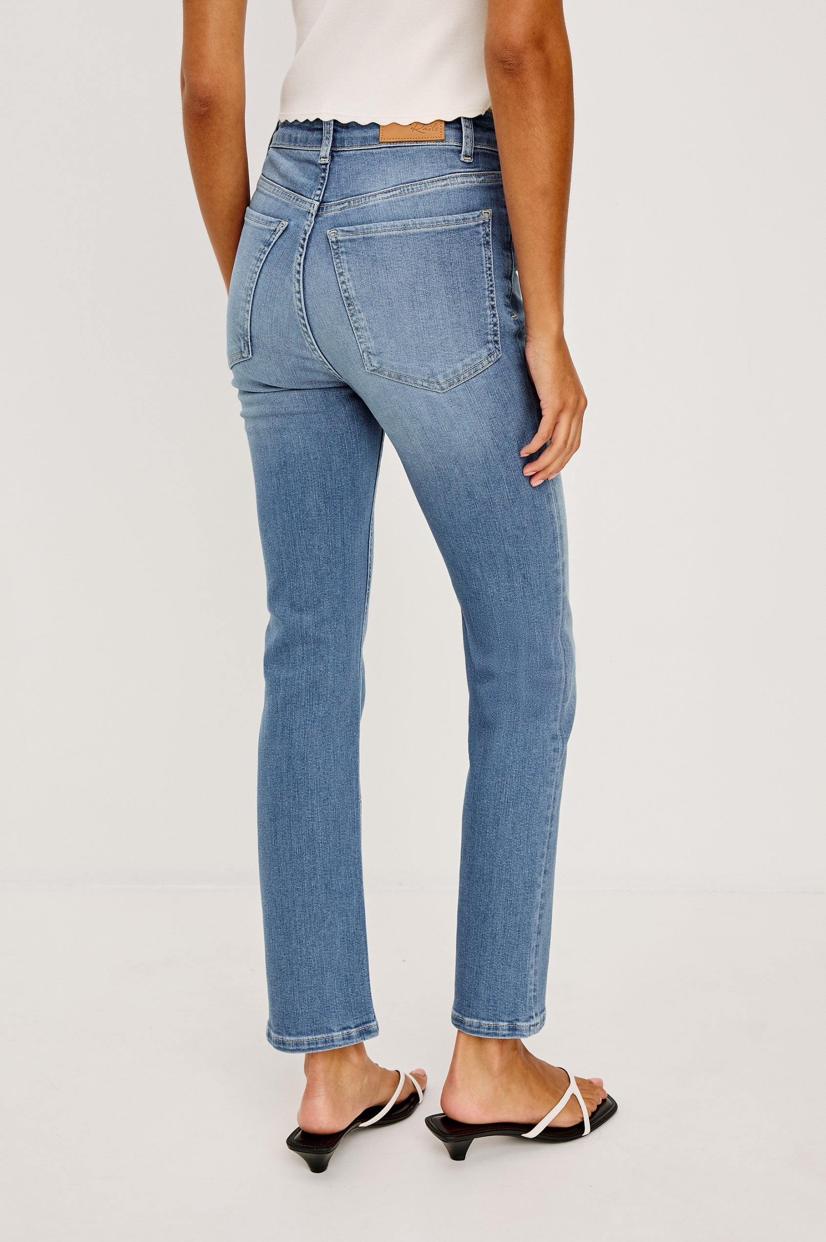Bixby Mid-Rise Slim Straight Jean in High Stretch Denim With 25″ Inseam, Zip Fly, and 5-Pockets in Vista Blue Colorway - Lower Body Back View Featured on Model