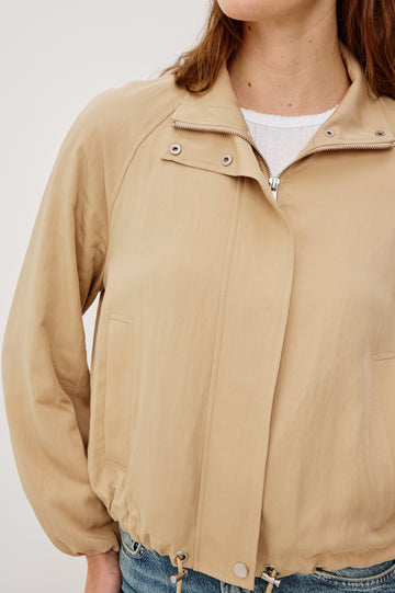 Blake Oversized Cropped Jacket With High Funnel Neck, Double-Button Closures, Long Drop Shoulder Sleeves With Elastic Cuffs, Side Pockets, and Drawstring Hem in Almond Colorway - Upper Body Close Up View Featured on Model