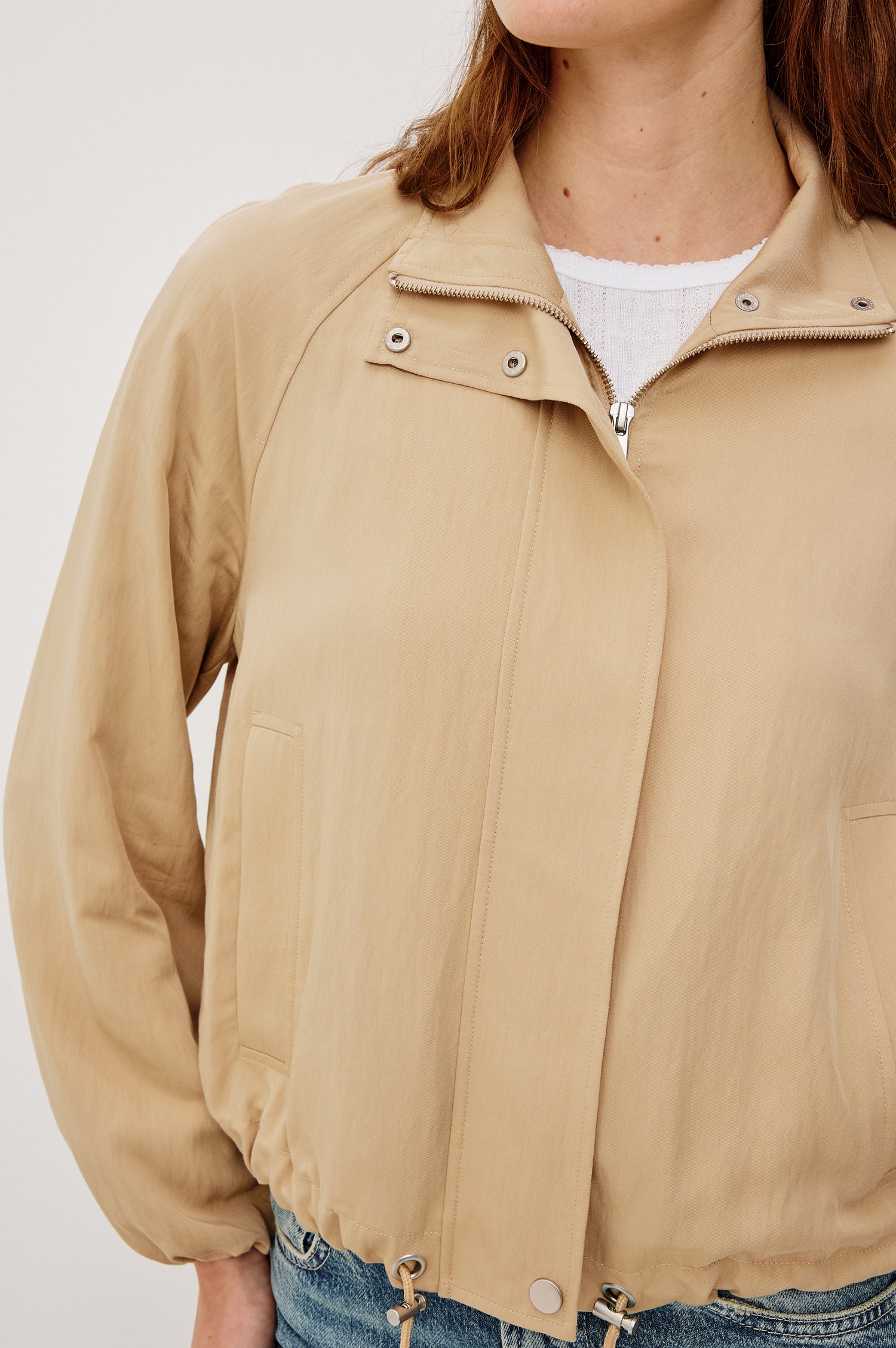 Blake Oversized Cropped Jacket With High Funnel Neck Double-Button Closures Long Drop Shoulder Sleeves With Elastic Cuffs Side Pockets and Drawstring Hem in Almond Colorway - Upper Body Close Up View Featured on Model