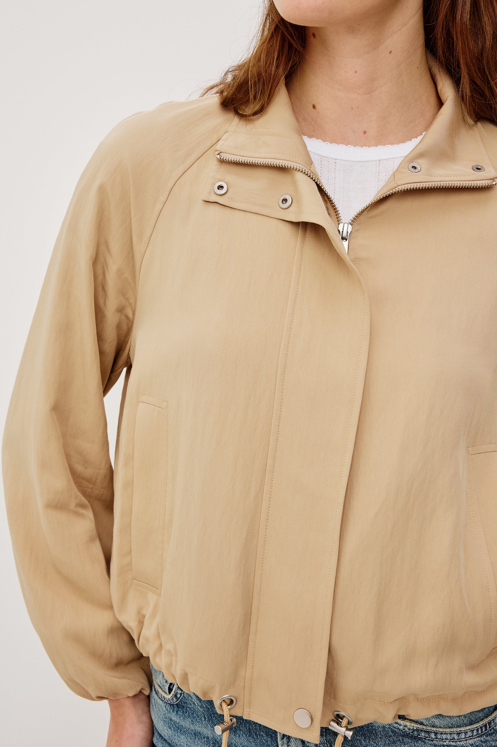 Blake Oversized Cropped Jacket With High Funnel Neck Double-Button Closures Long Drop Shoulder Sleeves With Elastic Cuffs Side Pockets and Drawstring Hem in Almond Colorway - Upper Body Close Up View Featured on Model