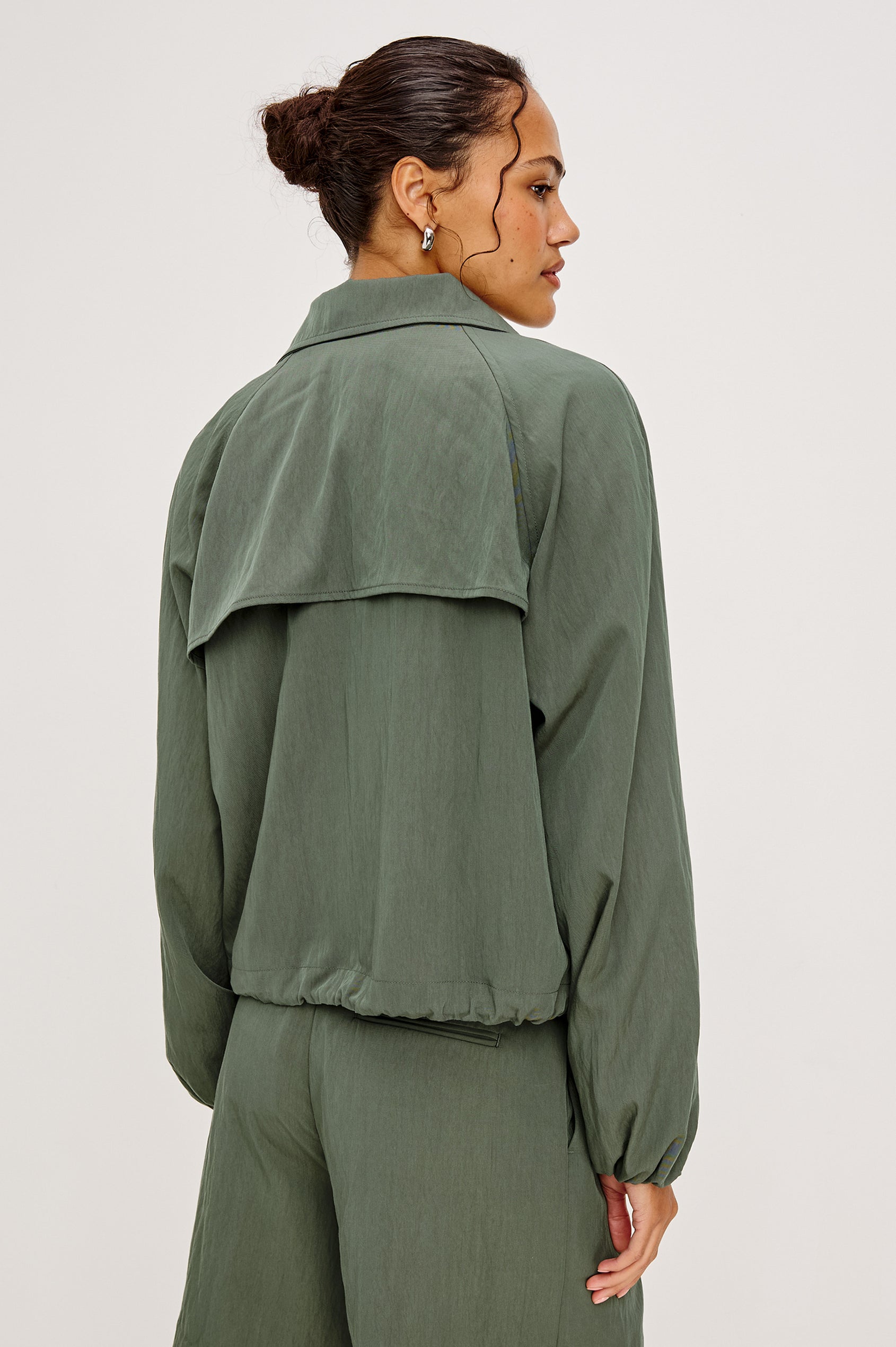 Black Jacket With Oversized Relaxed Fit, High Funnel Neck, Dropped Shoulders, Long Sleeves, Center-Front Ties, Side-Seam Zipper in Ivy Colorway - Upper Body Back View Featured on Model