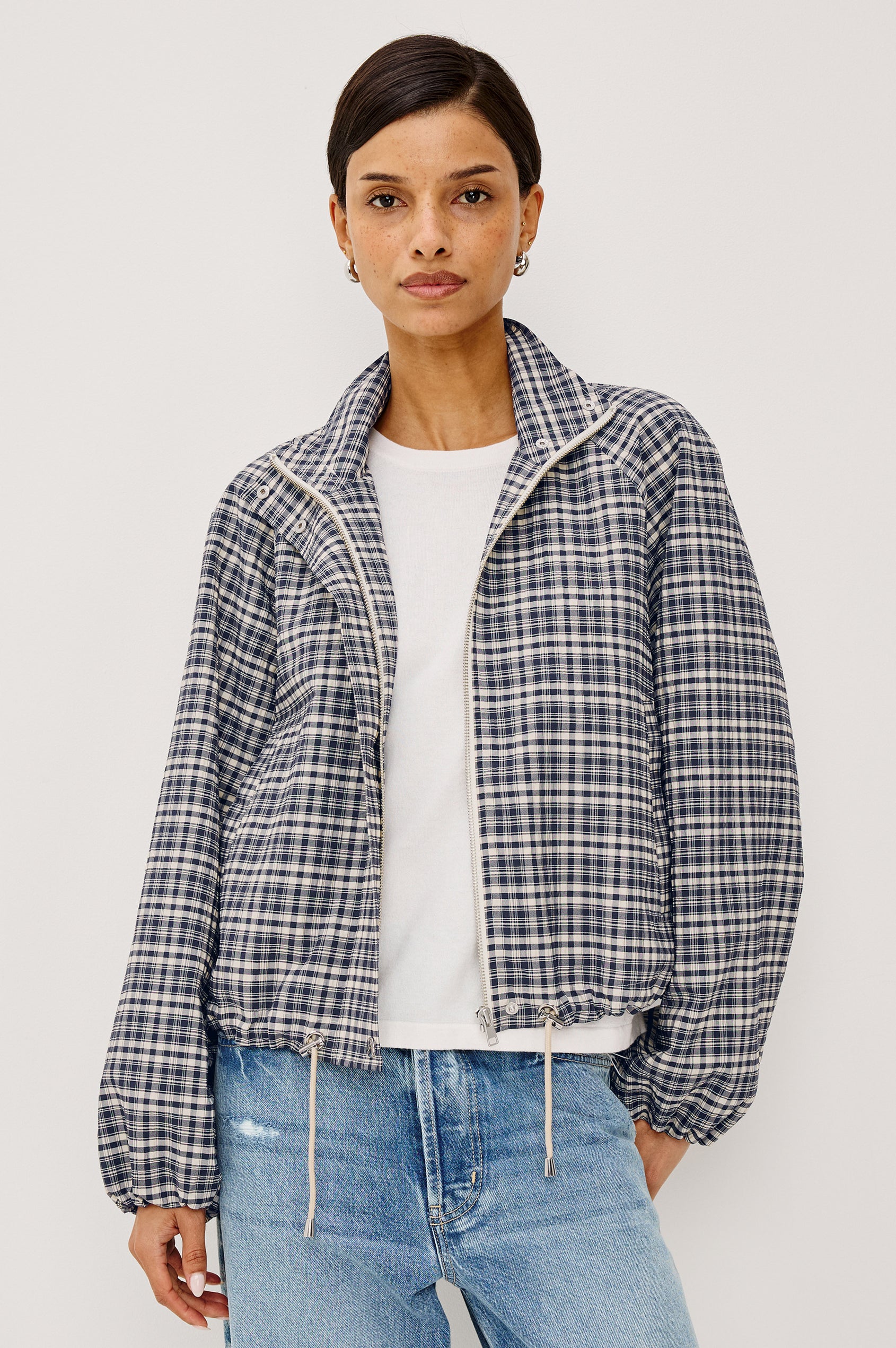 Blake Jacket in Crinkle Nylon Blend With Relaxed Fit, High Funnel Neck, Double Button Closures, Drop Shoulder Sleeves With Elastic Cuffs, and Cropped Drawstring Hem in Mini Check Colorway - Upper Body Front View Featured on Model