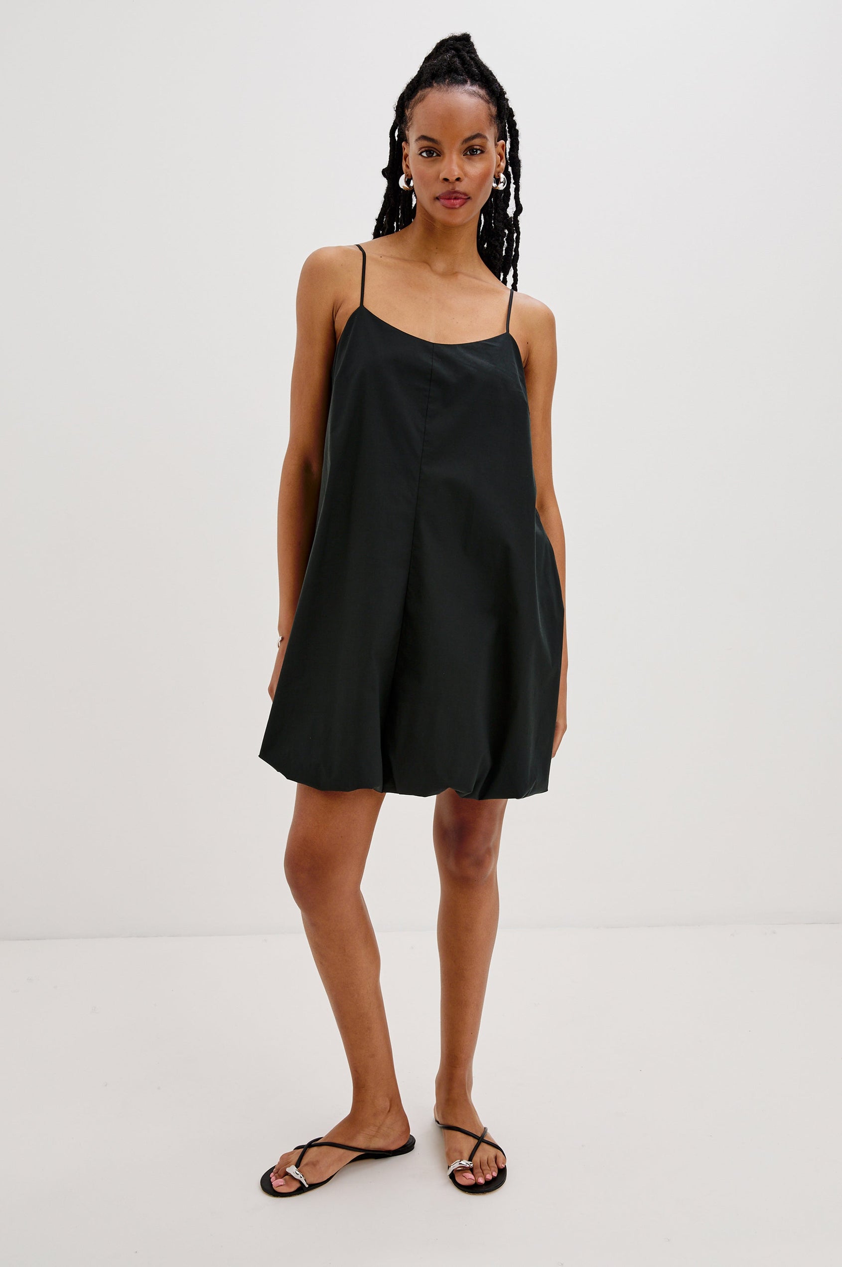 Blanca Bubble Hem Mini Dress with Spaghetti Straps and Side Pockets. Full Body Front View Shown on Model.