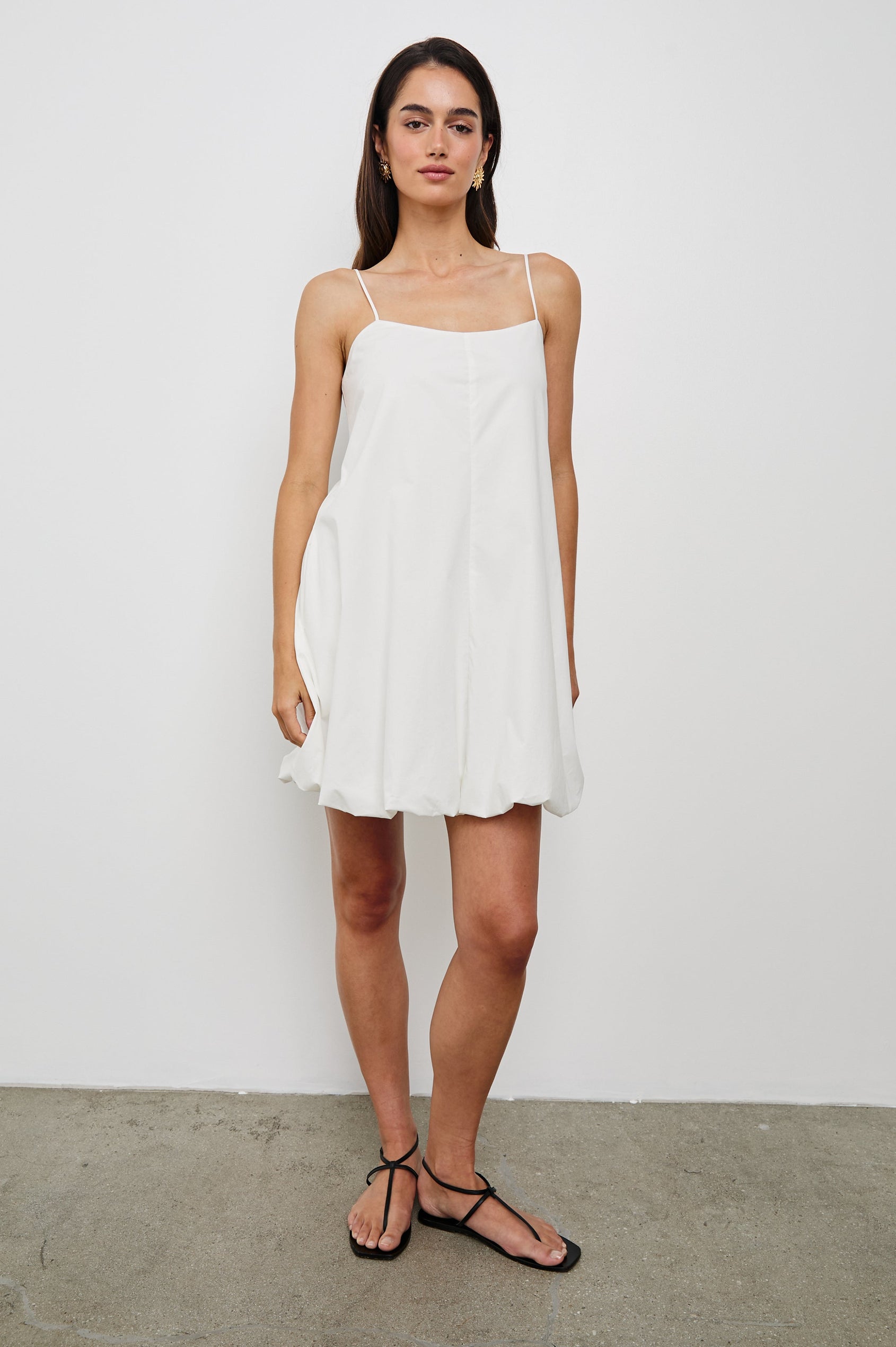 Bianca Mini Tank Dress with Spaghetti Straps, Side Pockets and a Bubble Hem in White Colorway. Full Body Front View Shown on Model.