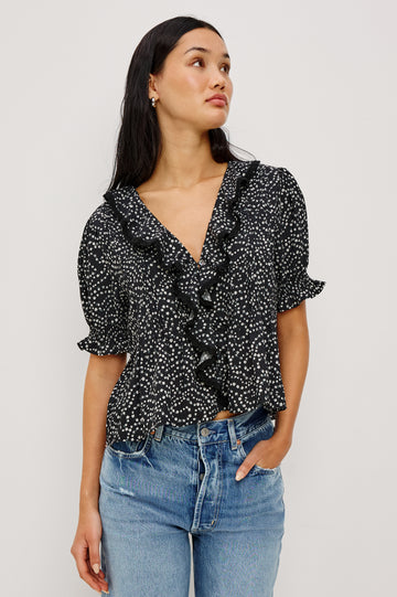 Bloom Poplin Top With Ruffle V-Neckline, Elbow-Length Puff Sleeves With Ruffled Cuffs, Pintuck Detailing, and Boxy Relaxed Fit in Mini Chain Daisies Colorway - Upper Body Front View Featured on Model