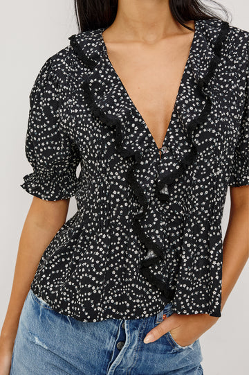 Bloom Poplin Top With Ruffle V-Neckline, Elbow-Length Puff Sleeves With Ruffled Cuffs, Pintuck Detailing, and Boxy Relaxed Fit in Mini Chain Daisies Colorway - Upper Body Front View Featured on Model