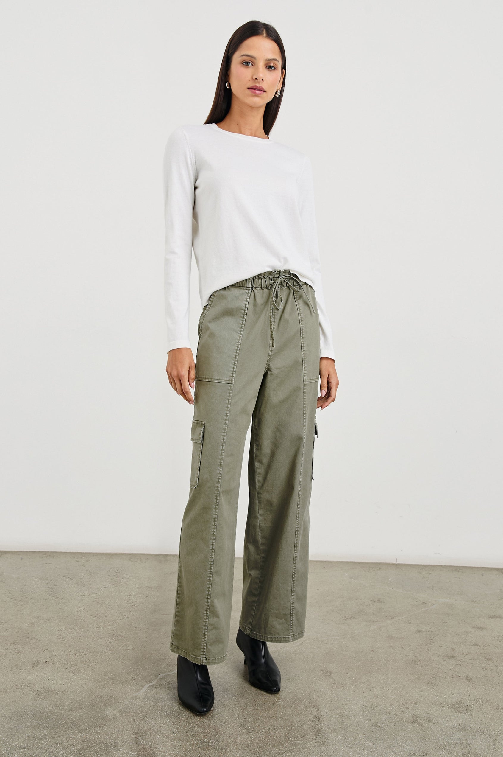 Bodie Pants with a Drawstring Waist, Front and Back Center Vertical Leg Seams, Two Front Pockets, Two Flap Side Pockets and Two Back Welt Pockets in Dark Olive Colorway - Front Full Body View Featured on Model  