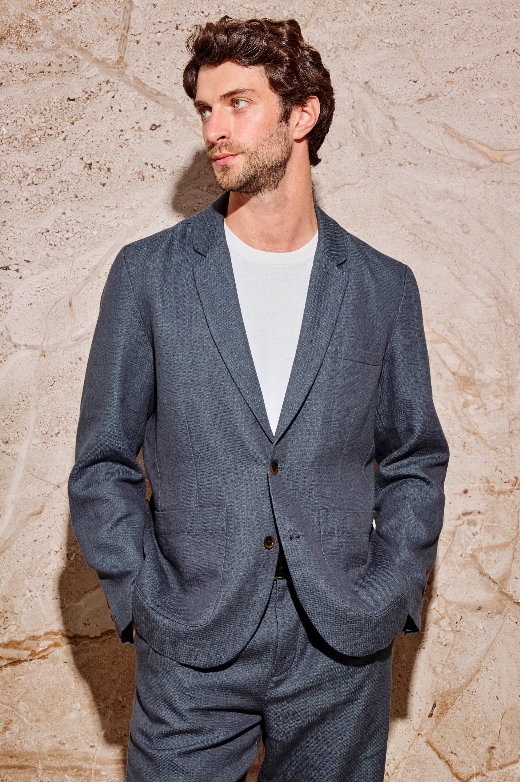 The Bond is a single breasted blazer with two buttons, one chest pocket and two patch pockets in a blue Meridian colorway. Front view featured on model.