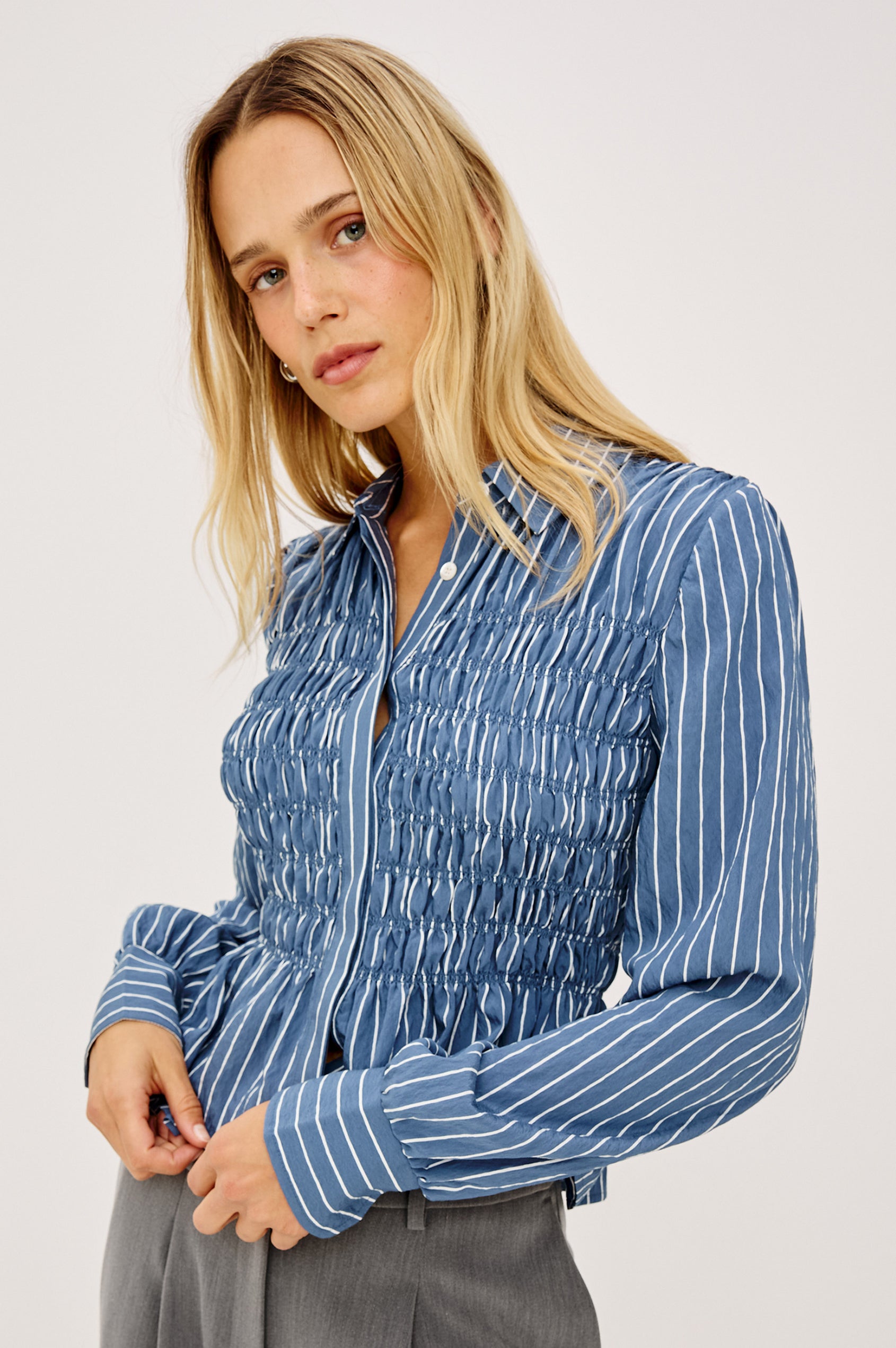 Bradshaw Shirt in Cotton Poplin With Button-Up Front, Collar, Smocked Body, Peplum Hem, and Bishop Sleeves in Washed Indigo Stripe Colorway - Upper Body Front View Featured on Model