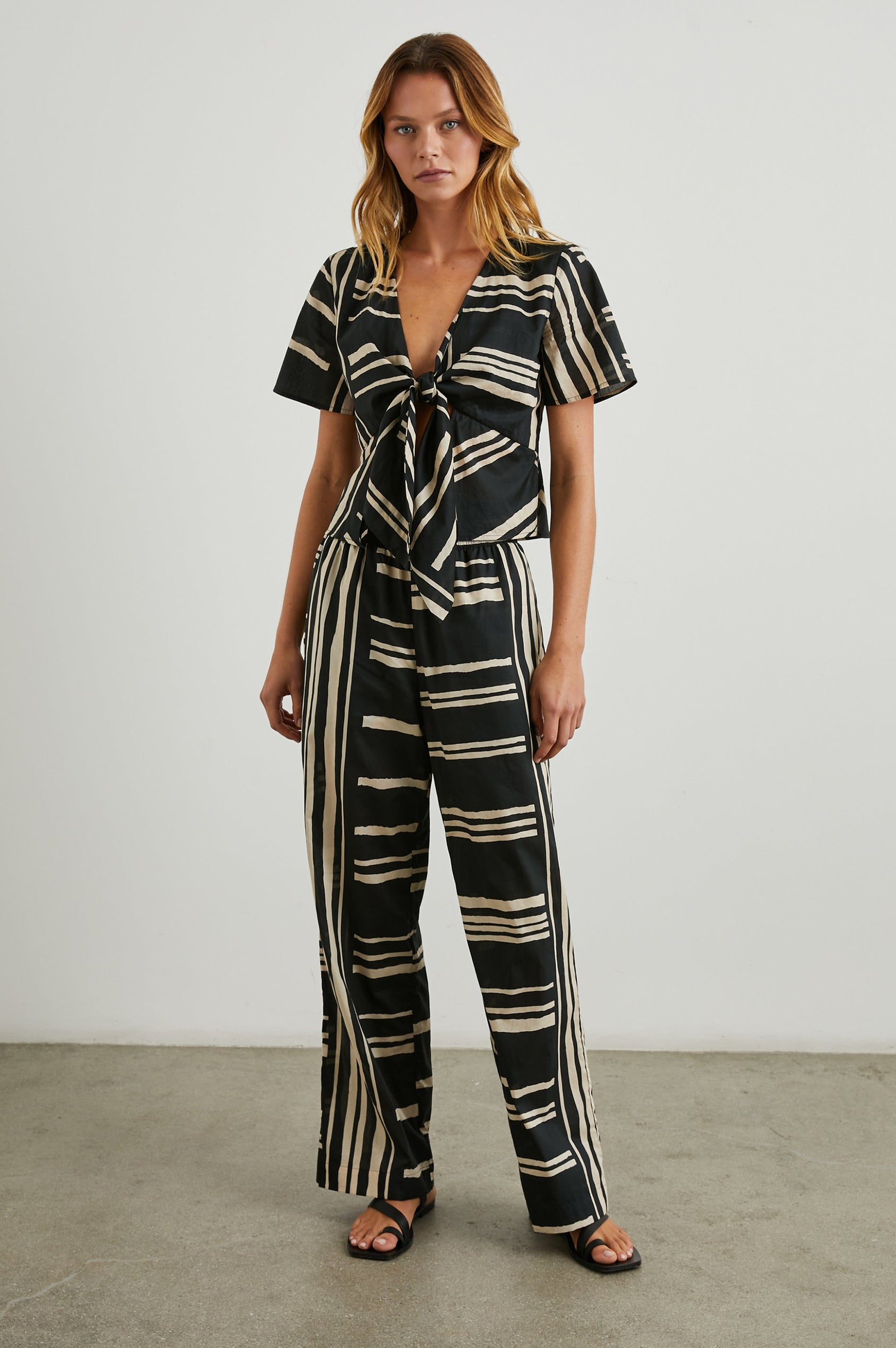 Brendon high-rise Pant with Elastic Waist and two front pockets in Island Stripe Colorway, with white vertical and horizontal stripes on black - Front Full Body View Featured on Model