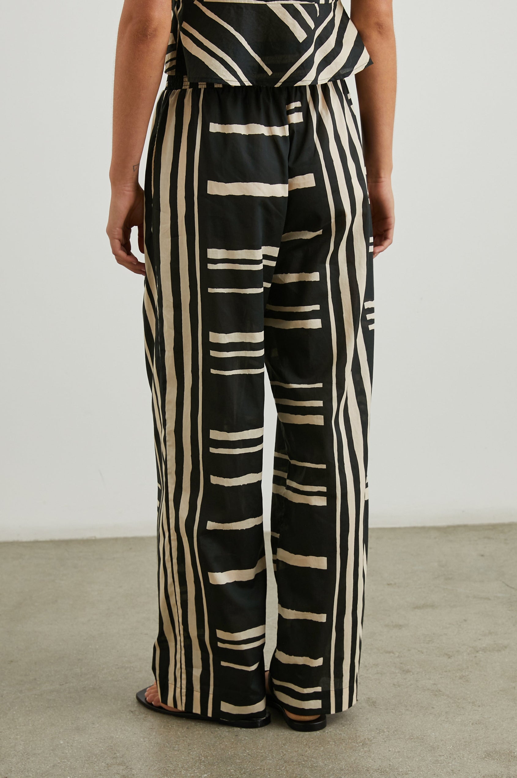 Brendon high-rise Pant with Elastic Waist and two front pockets in Island Stripe Colorway, with white vertical and horizontal stripes on black - Back View Featured on Model