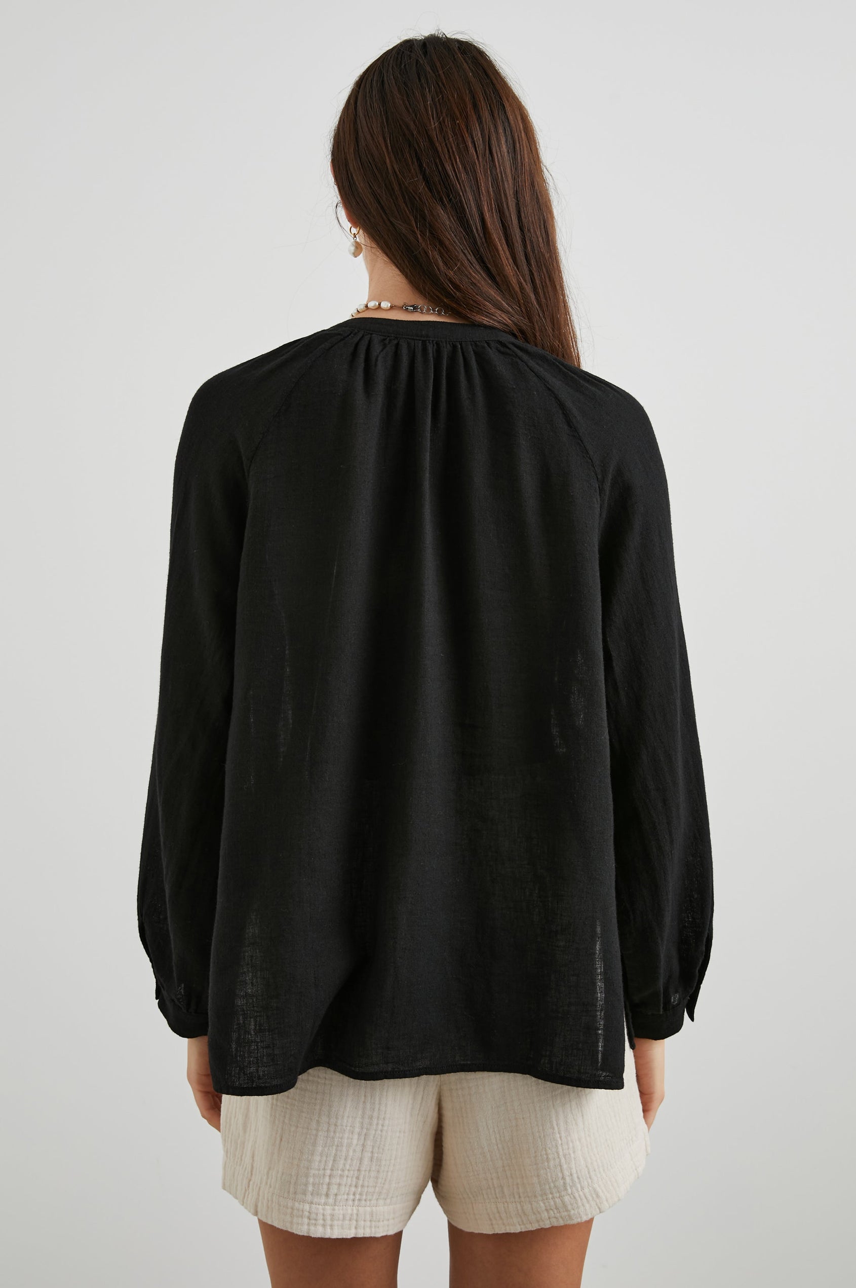 Brielle Long-Sleeve Top with a Deep V Neck with Ties and Pleats around the Neckline in Black Colorway - Back View Featured on Model