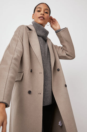 Bristol Knee-Length Double Breasted Coat with Two-Button Closure, Notched Lapels, Two Front Flap Pockets, Center Back Seams, and a Belted Back in Mink Colorway, a Light Brown - Front View Featured on Model  