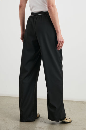 Brynn Pants with Two Front Pockets and Elastic Waist Band with White Trim in Black Colorway - Back View Featured on Model