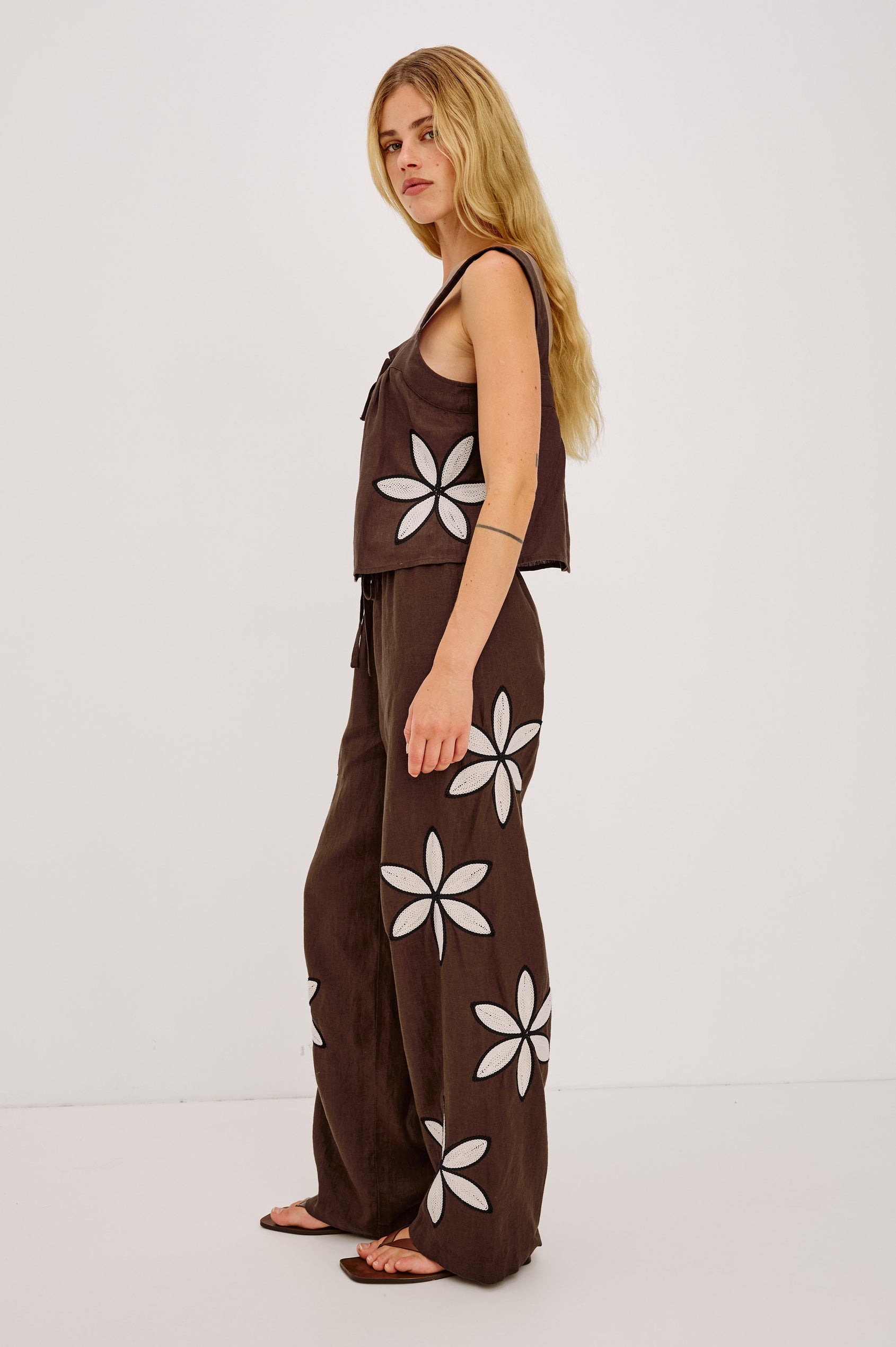 Emmie Wide-Leg Pant in Linen With High-Rise, Adjustable Waist Ties, and Side Pockets in Cocoa Floral Embroidery Colorway - Full Body Side View Featured on Model