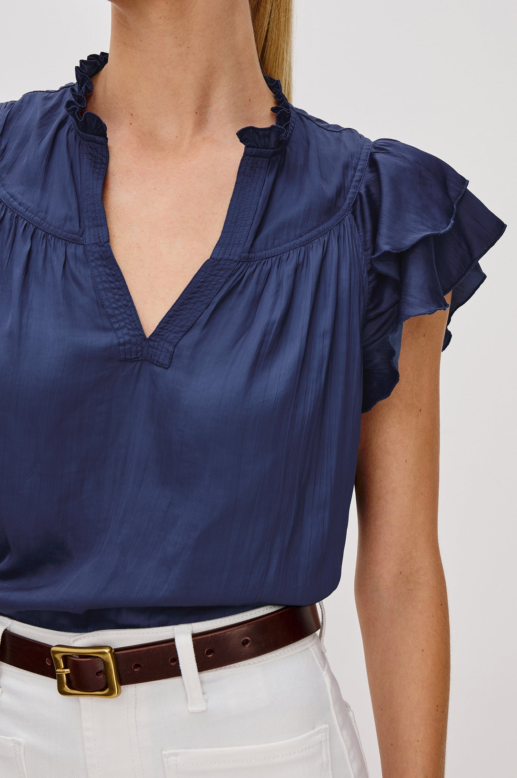 Calista V-Neck Ruffle Sleeve Blouse with a Ruffled Neckline and Gathered Front Yoke in Admiral Blue Colorway. Front Detail View Shown on Model.