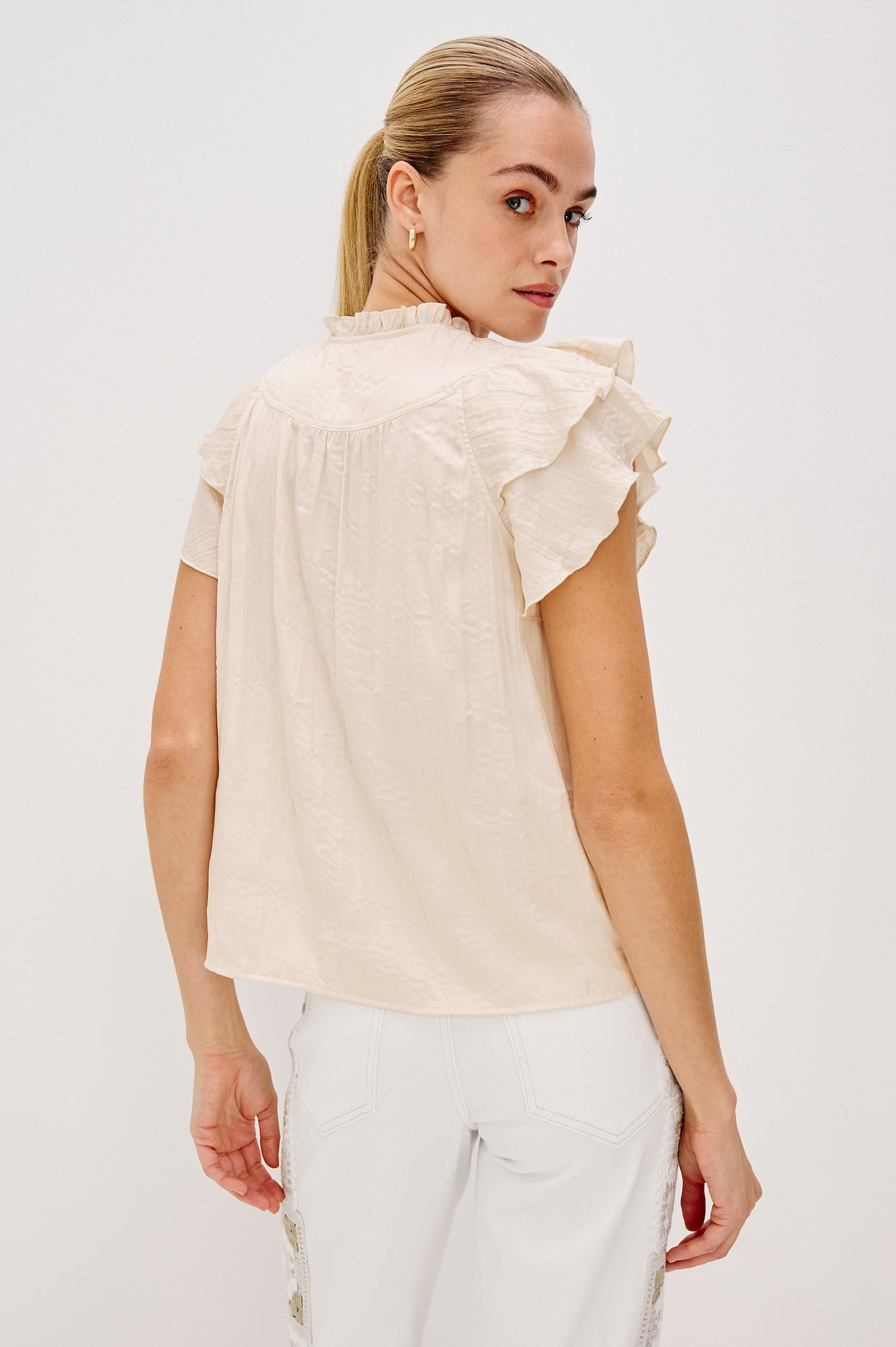 Calista V-Neck Ruffle Sleeve Blouse with a Ruffled Neckline and Gathered Front Yoke in Ivory Colorway. Full Body Back View Shown on Model.