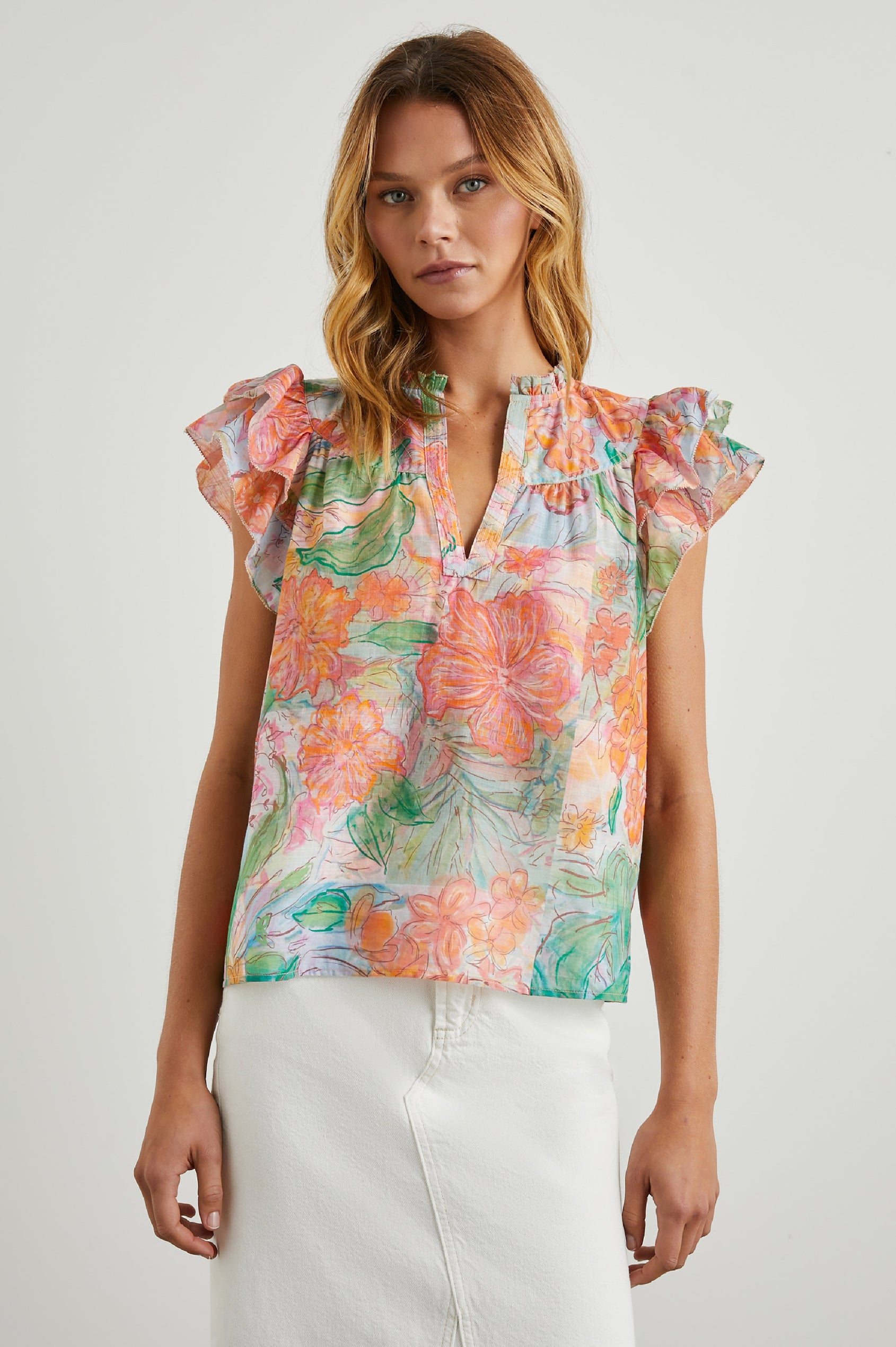 Calista Short Sleeve Top with Double Layer Flutter Sleeves, a V Neck with a Placket, a Ruffled Collar, and Light Ruching Along the Yoke in Tropics Colorway, Floral Print in Oranges, Greens and Blue - Front View Featured on Model 