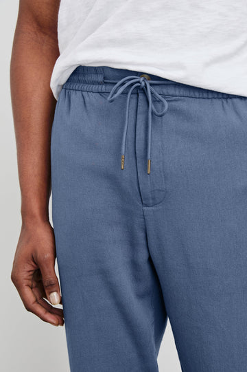 Callum Pants with a Drawstring Waist, Two Front Pockets and a Back Patch Pocket in Washed Blue Colorway - Front View Featured on Model