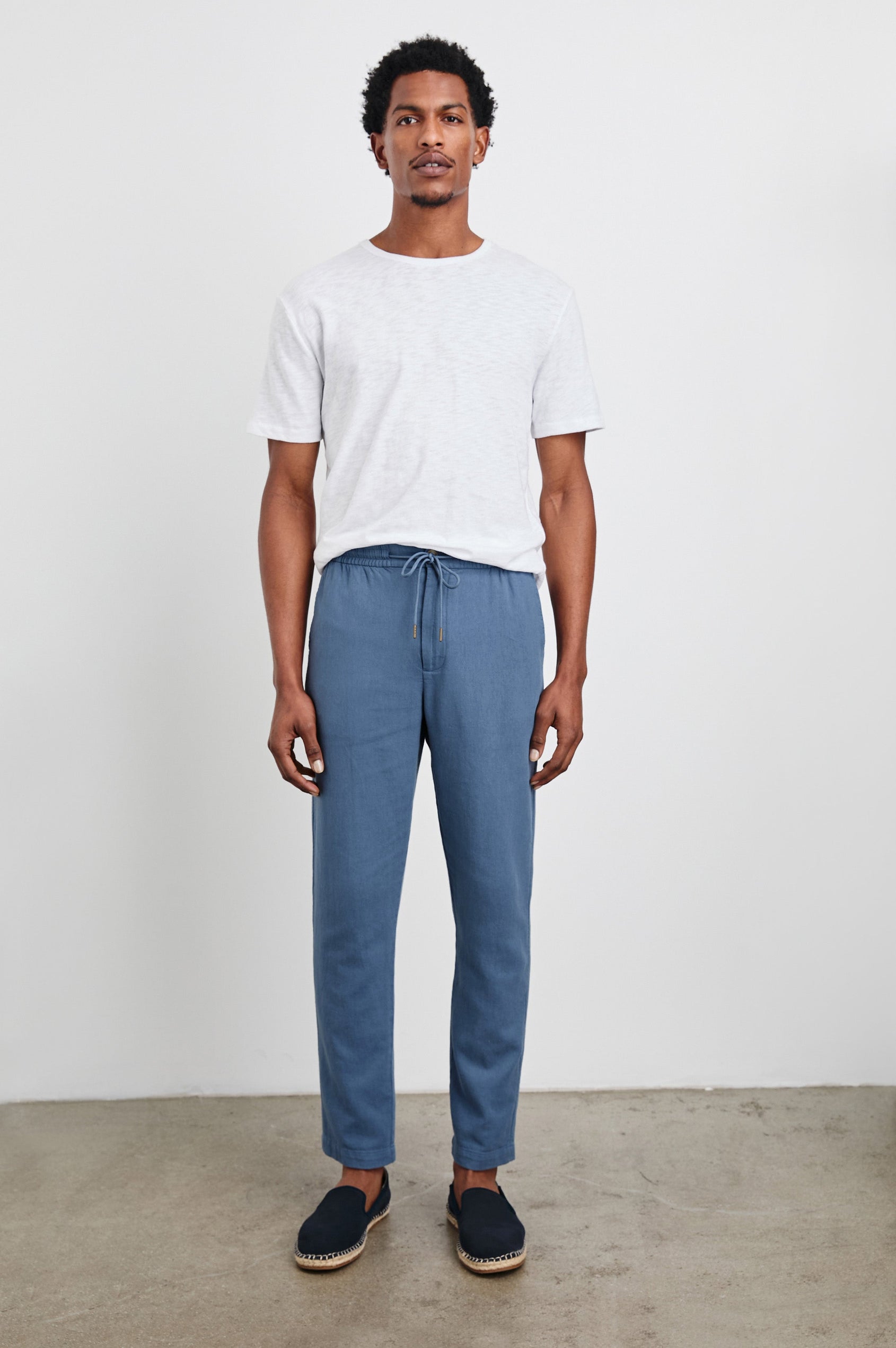 Callum Pants with a Drawstring Waist, Two Front Pockets and a Back Patch Pocket in Washed Blue Colorway - Full Body Front View Featured on Model.
