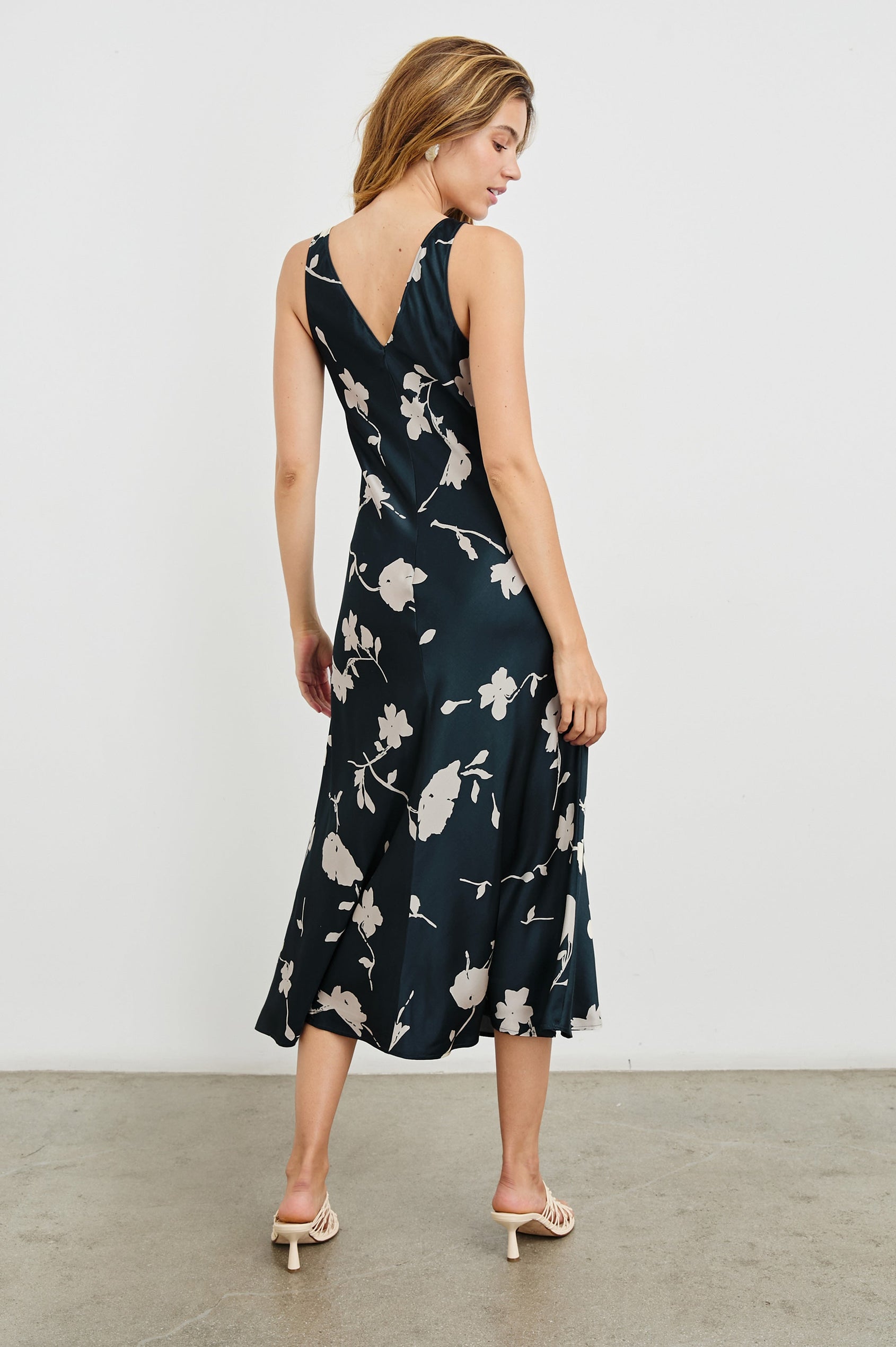 Camellia Sleeveless Midi Dress with Shoulder Straps and a V Neck in Midnight Roses Colorway, with cream flowers on Midnight - Back Full Body View Featured on Model