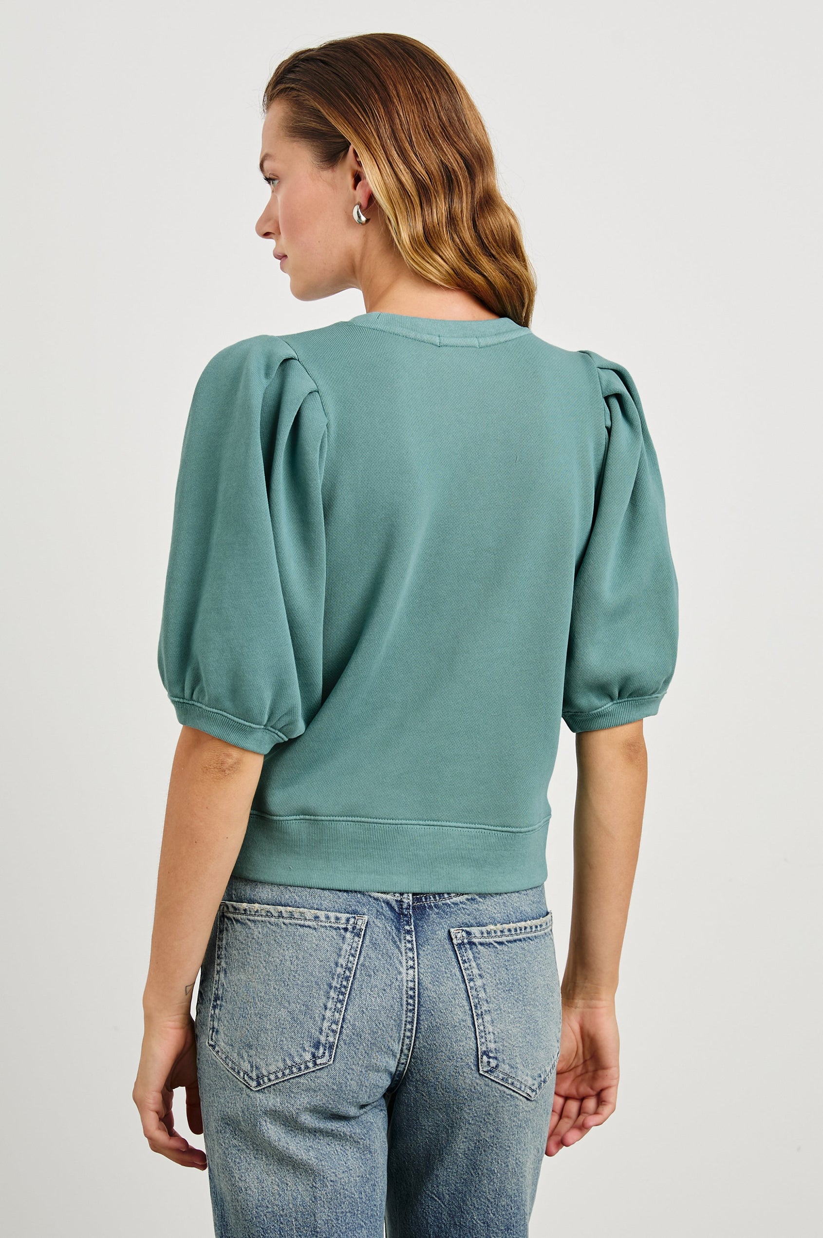 Camy Sweatshirt with Elbow Length Puff Sleeves and a Crew Neck in Stone Blue Colorway - Back View Featured on Model 