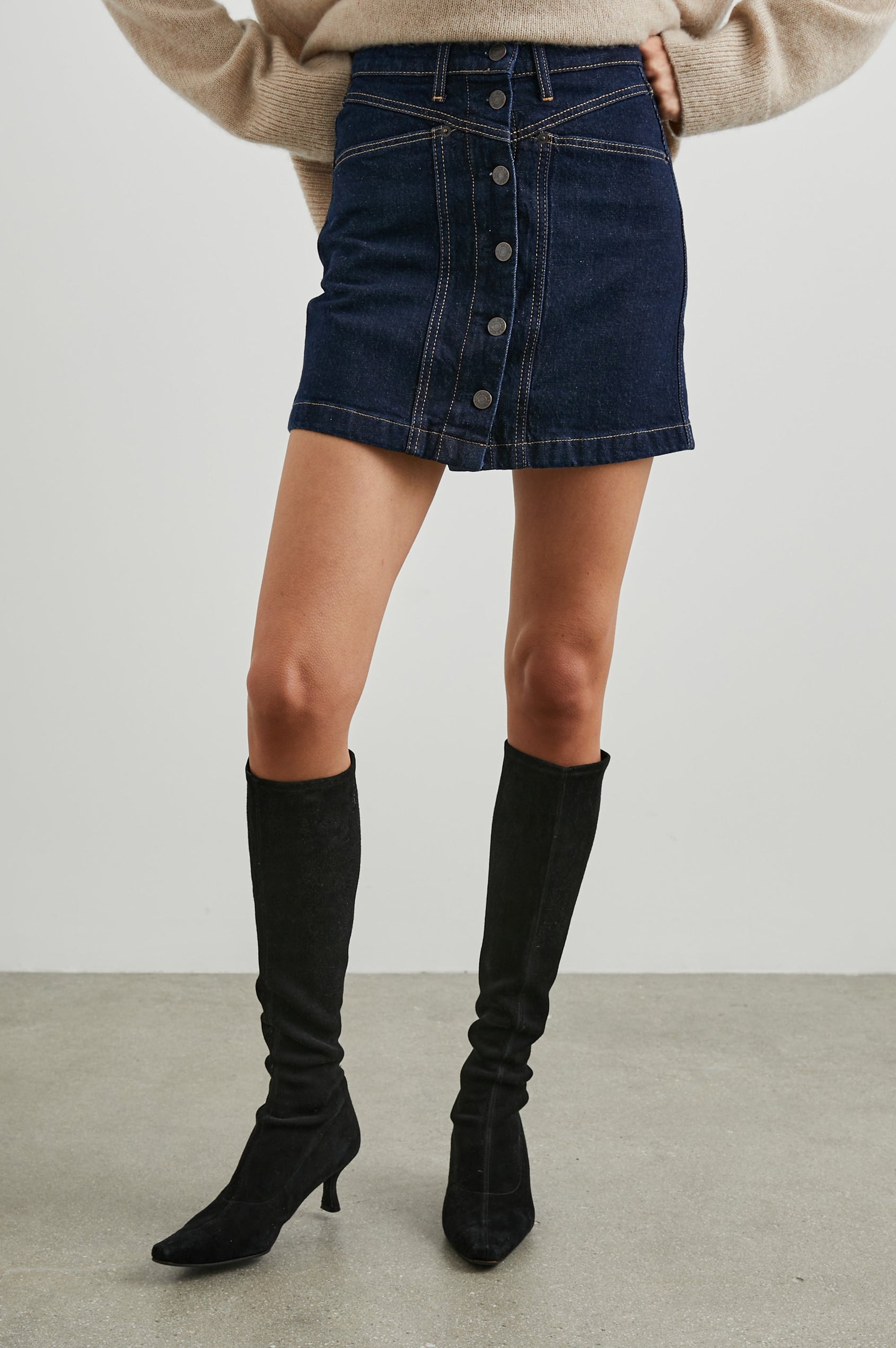 Canyon Denim Mini Skirt with a Full Button Front, Belt Loops, Two Front Pockets and Two Back Patch Pockets in Midnight Blues Colorway - Front View Featured on Model