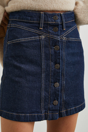 Canyon Denim Mini Skirt with a Full Button Front, Belt Loops, Two Front Pockets and Two Back Patch Pockets in Midnight Blues Colorway - Back View Featured on Model