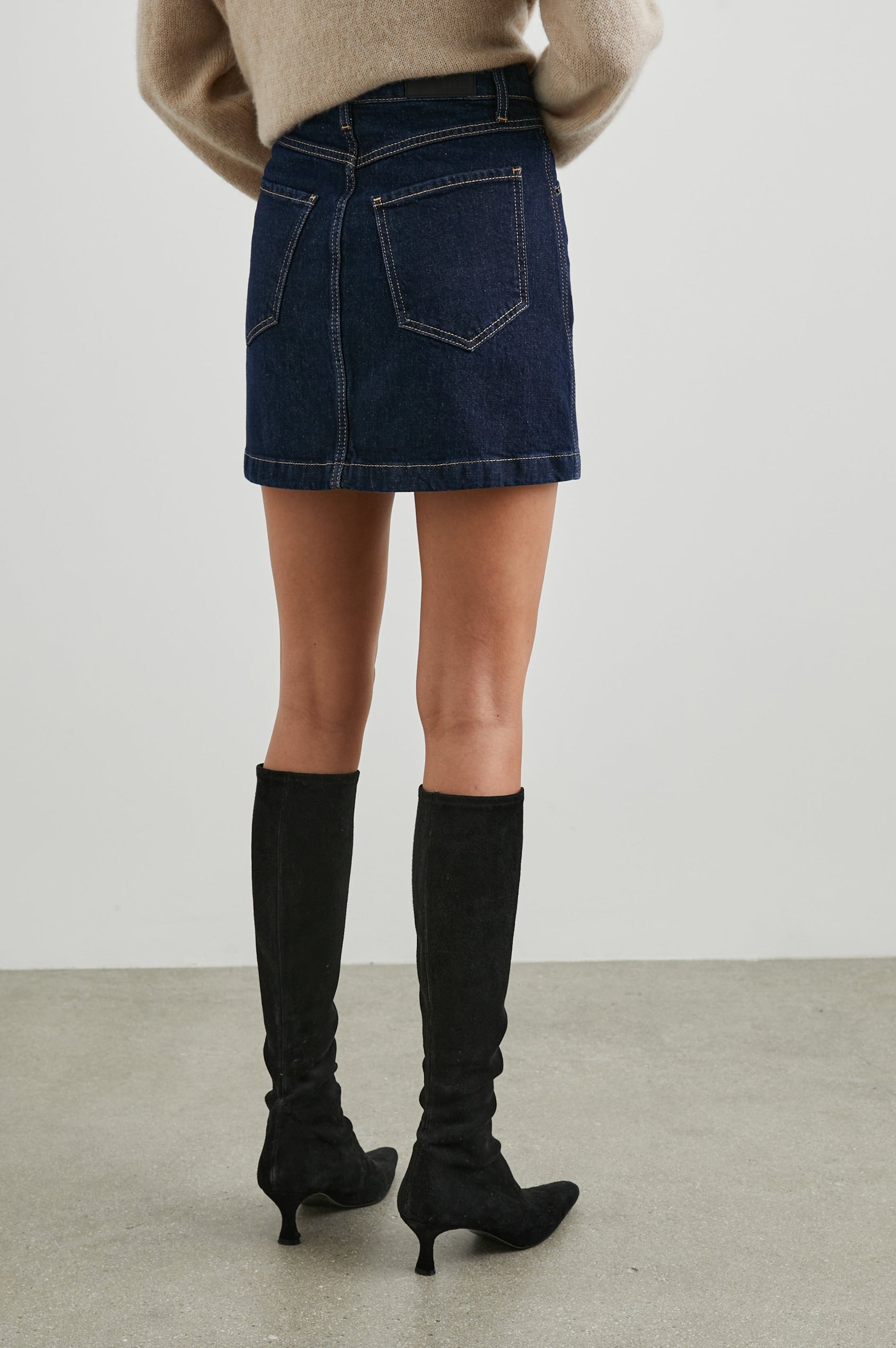 Canyon Denim Mini Skirt with a Full Button Front, Belt Loops, Two Front Pockets and Two Back Patch Pockets in Midnight Blues Colorway - Back View Featured on Model