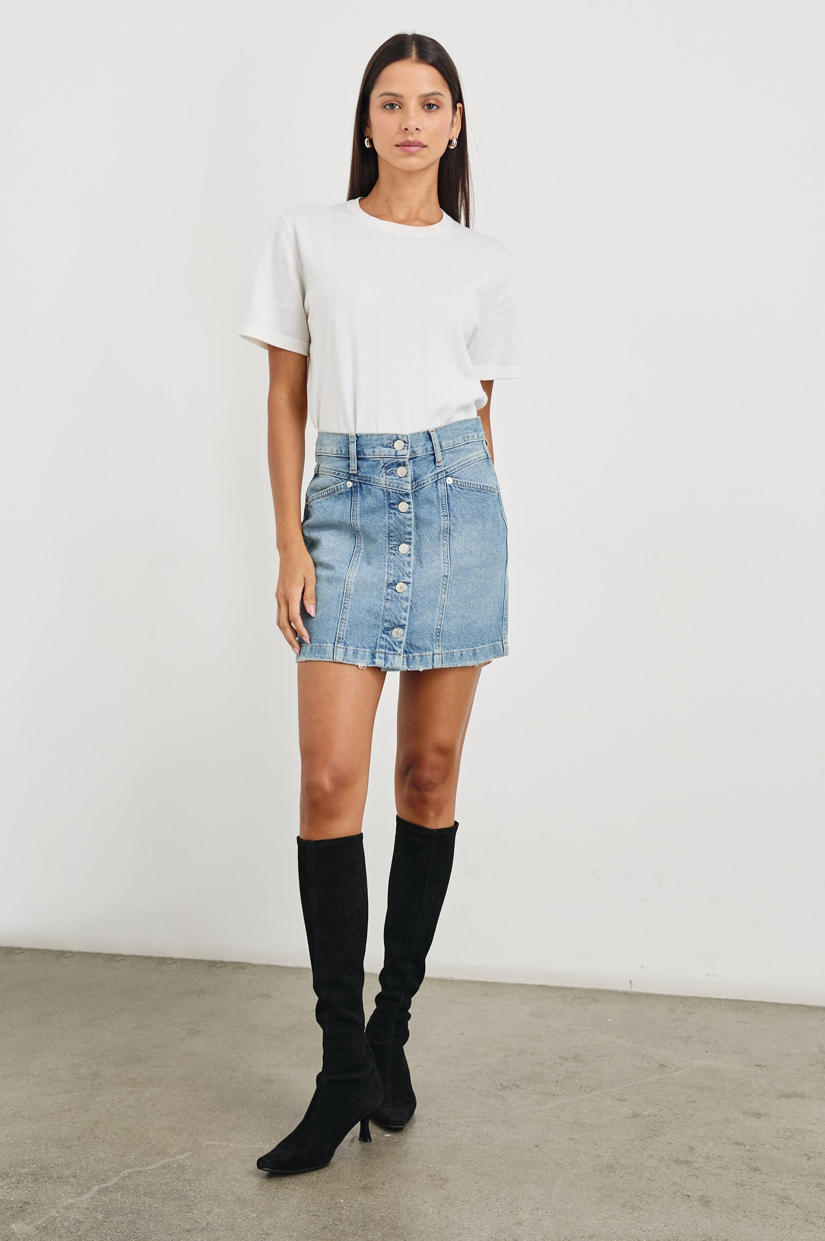 Canyon Denim Mini Skirt with a Full Button Front, Belt Loops, Light Fraying along the Hem, Two Front Pockets and Two Back Patch Pockets in Old Indigo Colorway - Front Full Body View Featured on Model