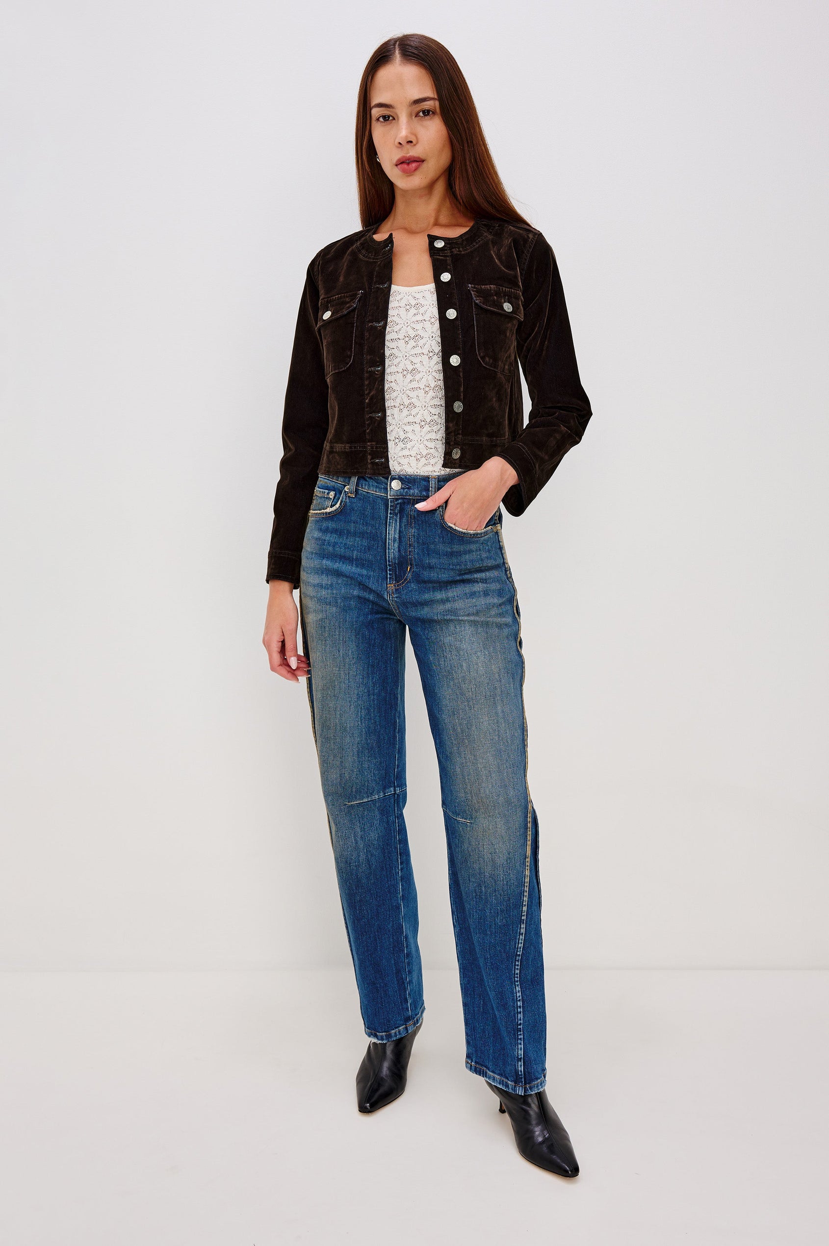 The Capistrano is a cropped denim jacket with a crewneck, it has a button front and two chest pockets in Chocolate Flocking colorway. Front full body view featured on model.