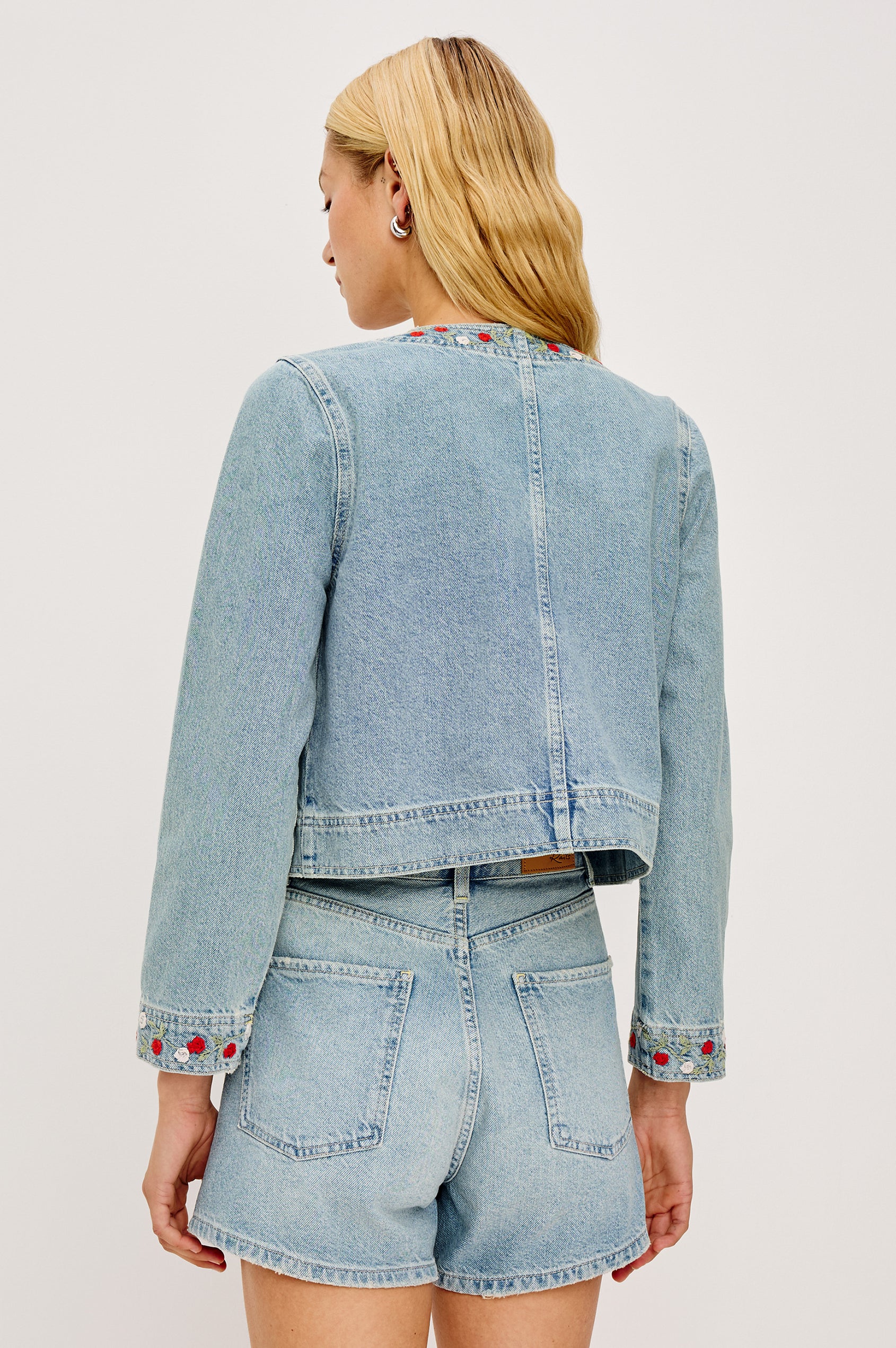 Capistrano Lady Jacket in Recycled Cotton Denim Blend With Floral Embroidery, Chest Flap Buttoned Pockets, and Long Sleeves in Dainty Rose Colorway - Upper Body Back View Featured on Model