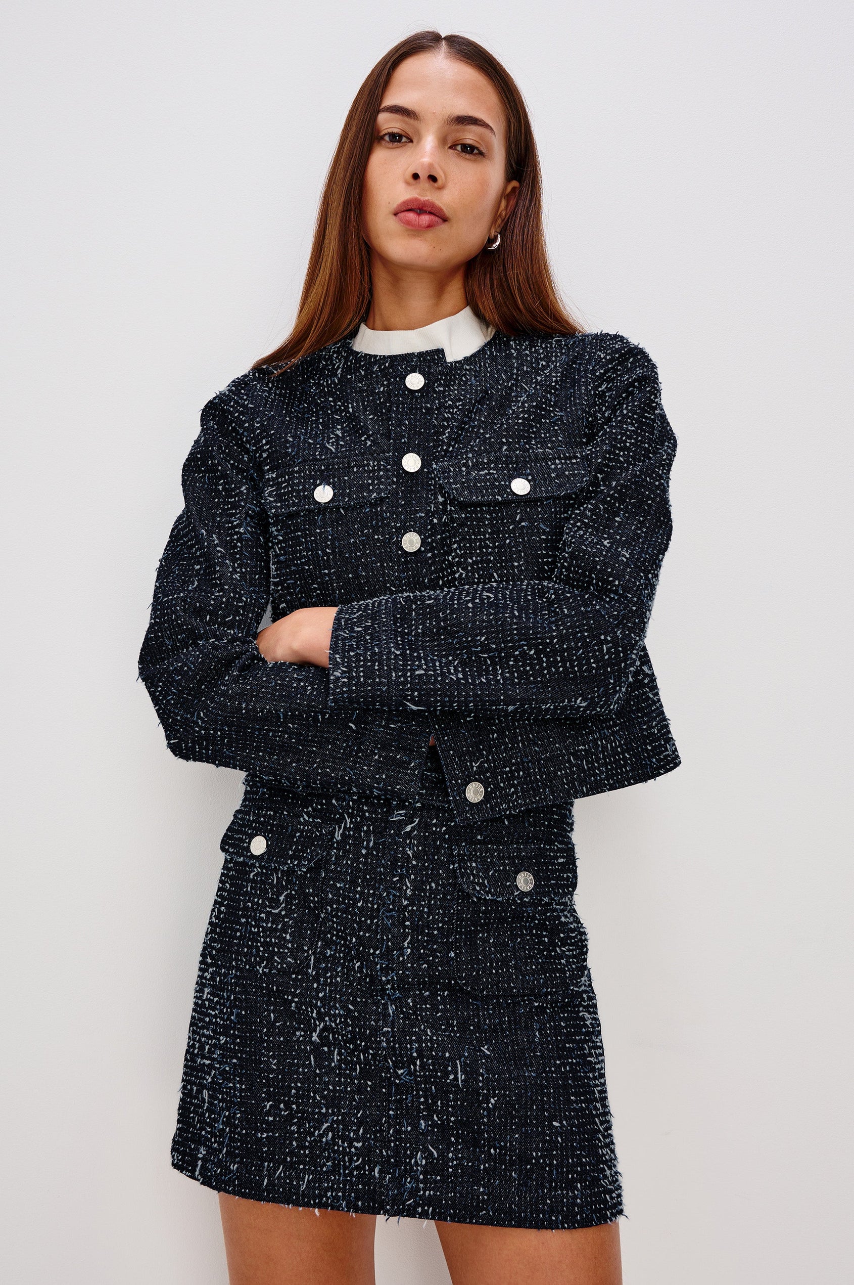 The Capistrano is a cropped denim jacket with a crewneck, it has a button front and two chest pockets in Denim Tweed colorway. Front view featured on model.