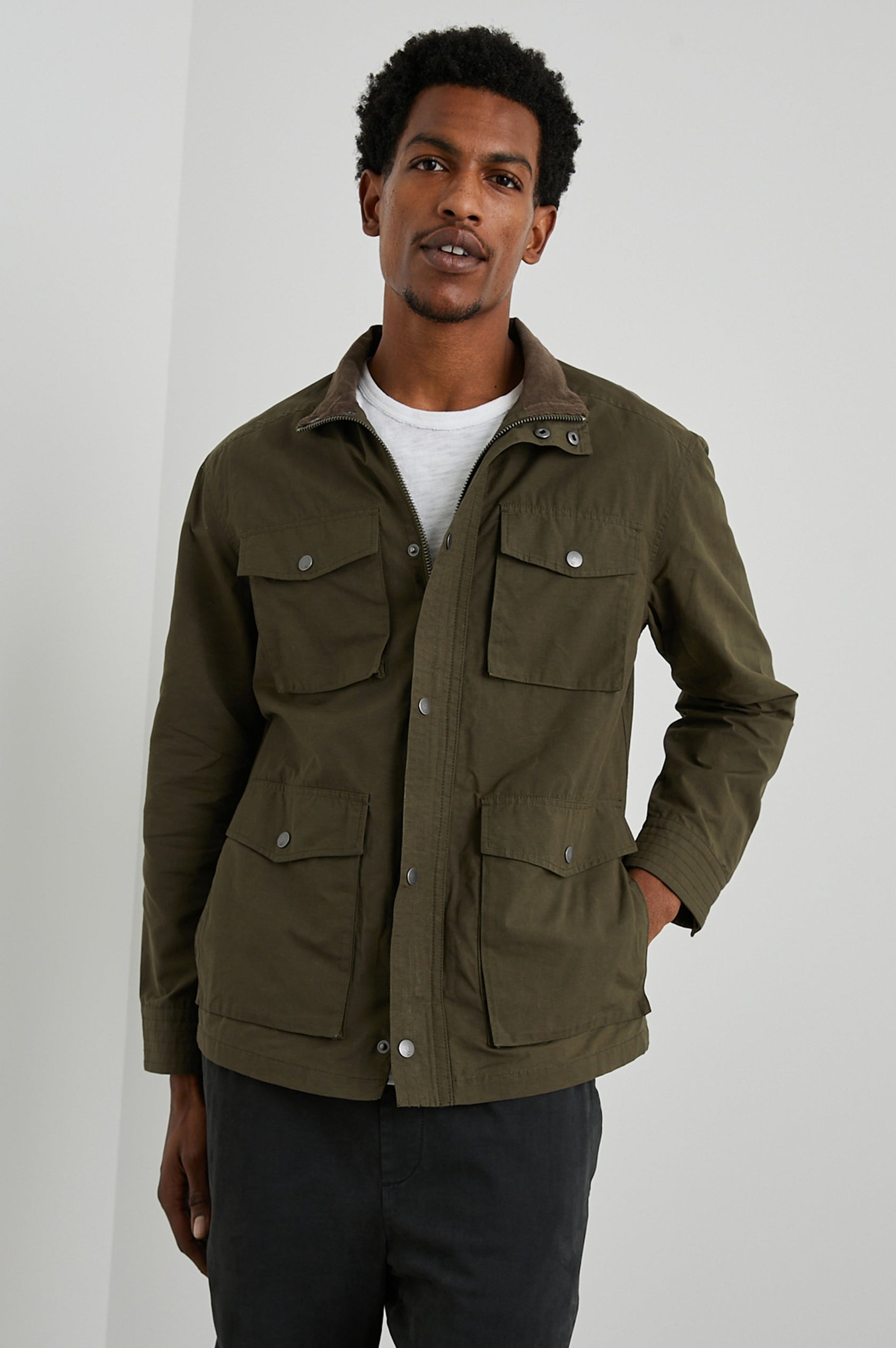 Cardiff Jacket with a Snap and Zipper Closure, Two Chest Snap Flap Pockets and Two Front Snap Flap Pockets in Dark Olive Colorway, with an Interior of Multicolor Horizontal Stripes - Front View Featured on Model  