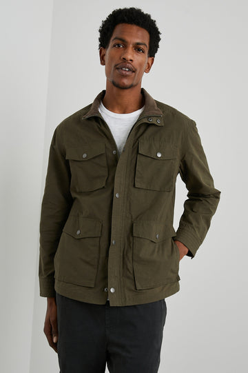 Cardiff Jacket with a Snap and Zipper Closure, Two Chest Snap Flap Pockets and Two Front Snap Flap Pockets in Dark Olive Colorway, with an Interior of Multicolor Horizontal Stripes - Front View Featured on Model  
